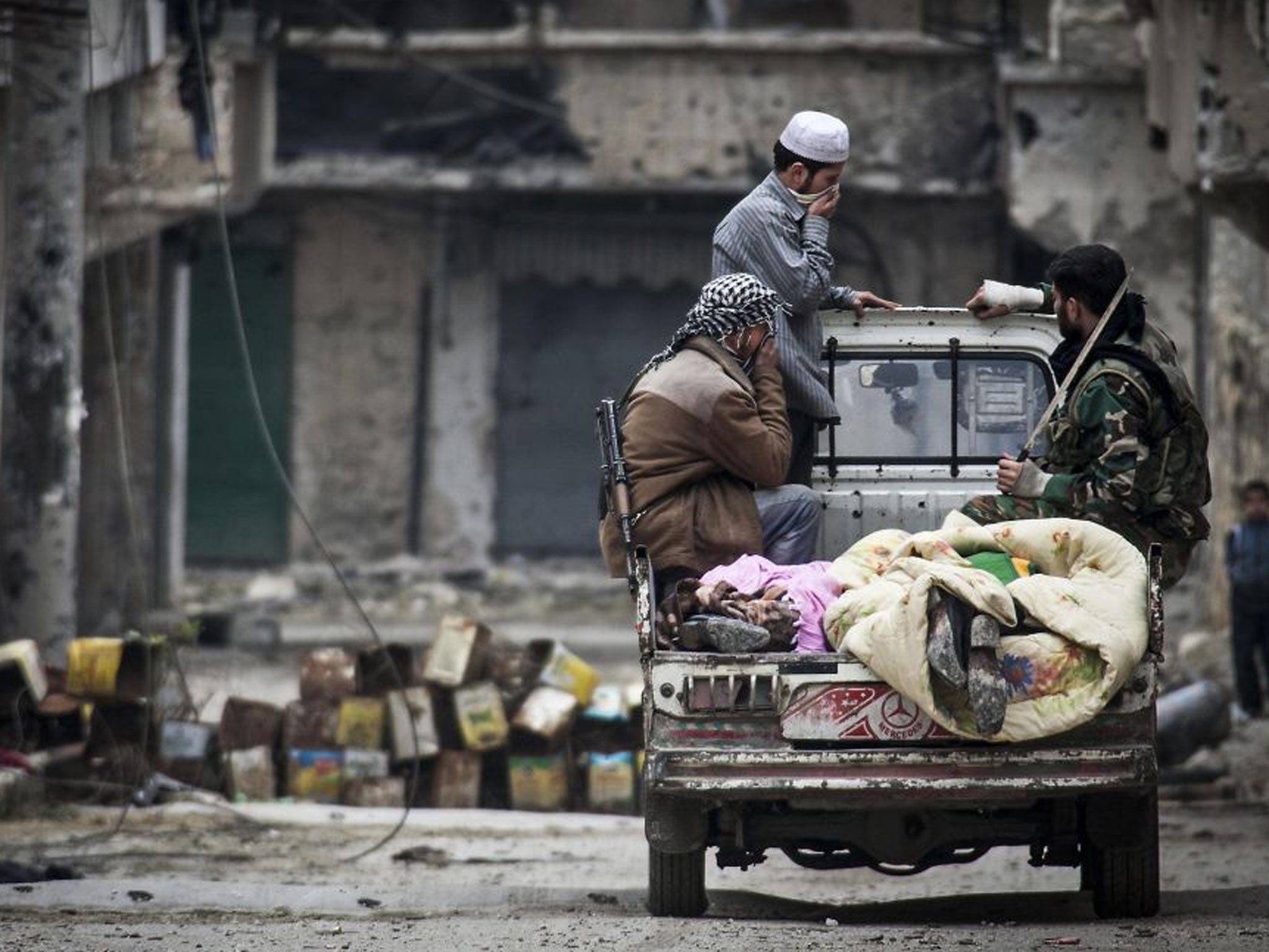 Free Syrian Army fighters take away the dead during a break in fighting