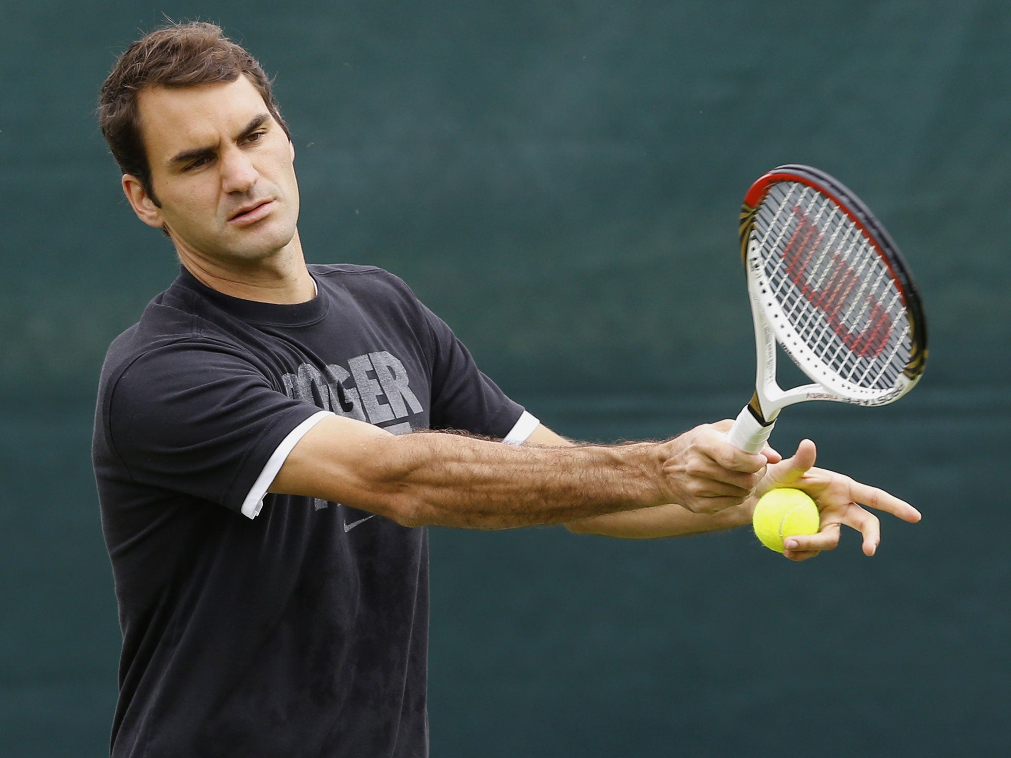 Defending Wimbledon champion, the Swiss Roger Federer plays a return during a training session