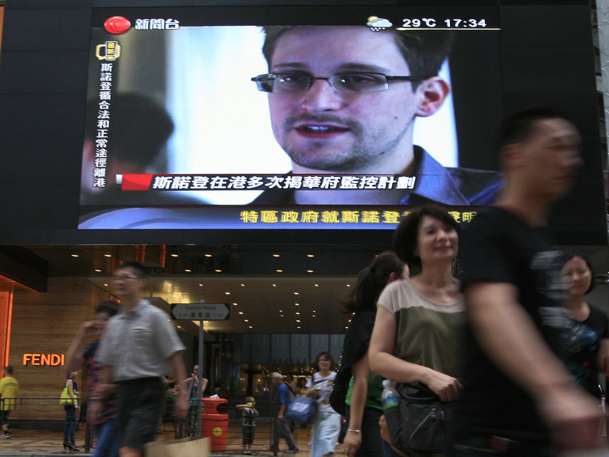 A TV screen shows a news report about Edward Snowden in Hong Kong