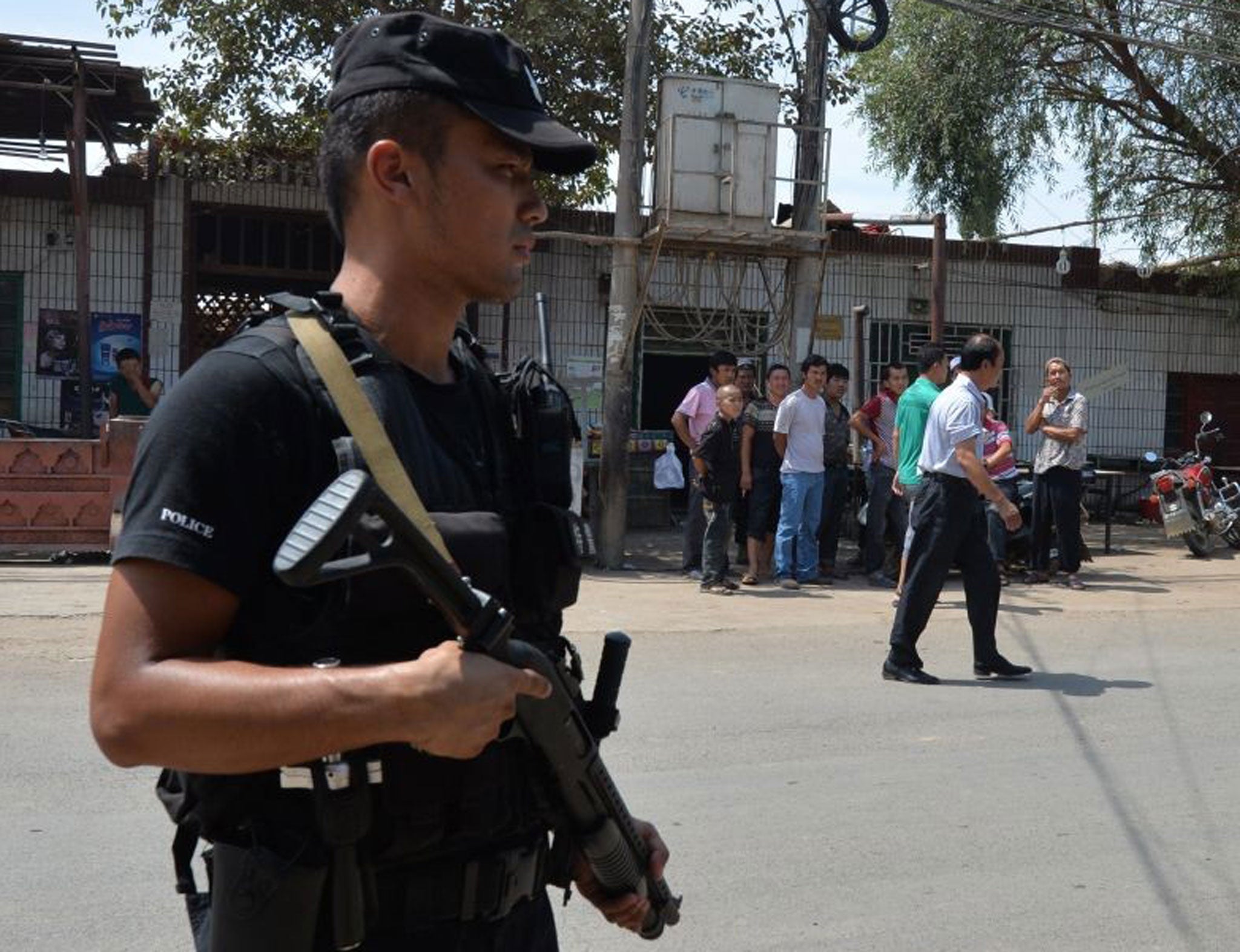 Armed police patrol the road leading into Lukqun