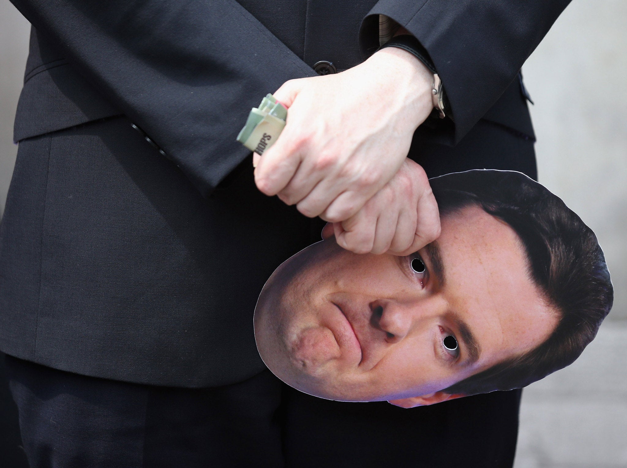 A member of the public and commercial services union holds a Chancellor of the Exchequer George Osborne face mask at a demonstration on Whitehall on June 27, 2013 in London, England. The union members were expressing their opposition to the 11.5 billion GBP cut to public spending outlined by the Chancellor of the Exchequer George Osborne in the House of Commons yesterday.