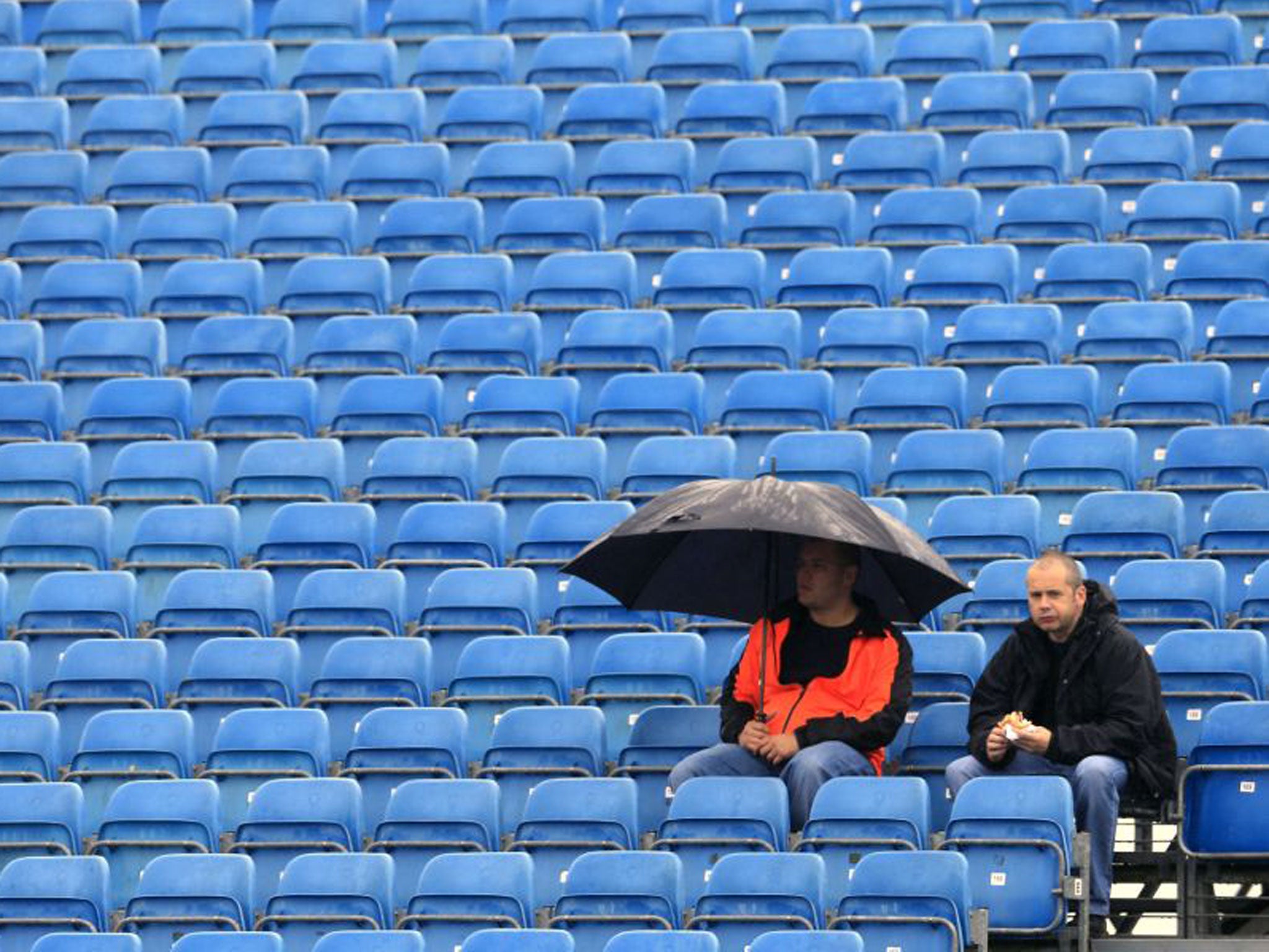 Spectators wait in the rain for the first practice runs at Silverstone