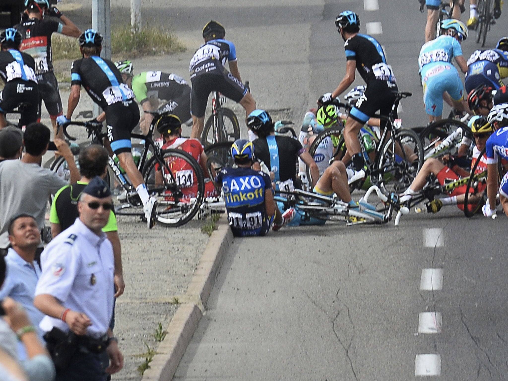Alberto Contador (no 91) sits on the road after the crash