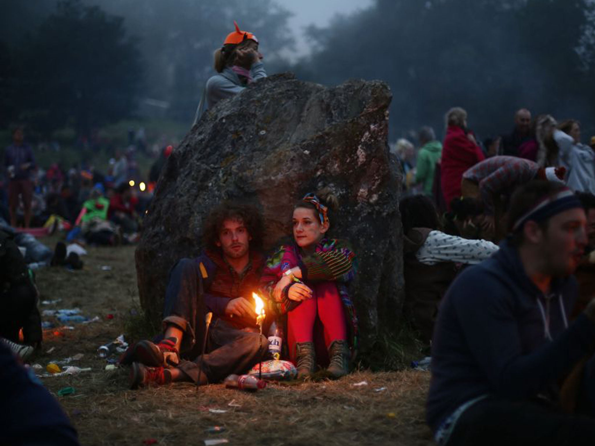 Festival-goers at dawn in the Stone Circle as the final day of the Festival begins