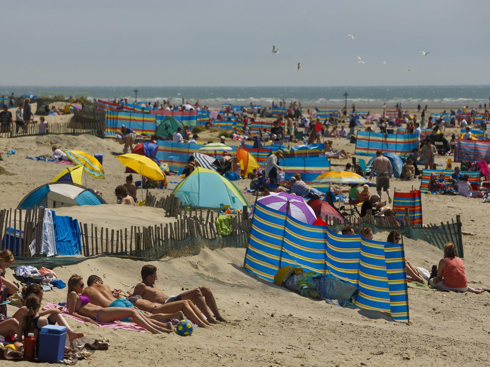 Day-trippers enjoying the sun on West Wittering beach near Chichester, West Sussex