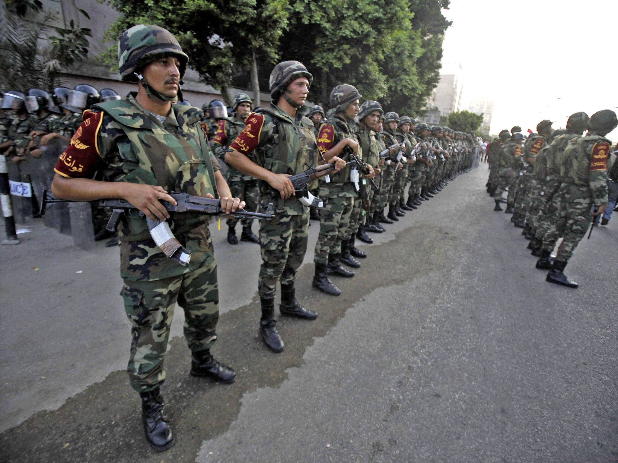 Army soldiers take their positions in front of protesters