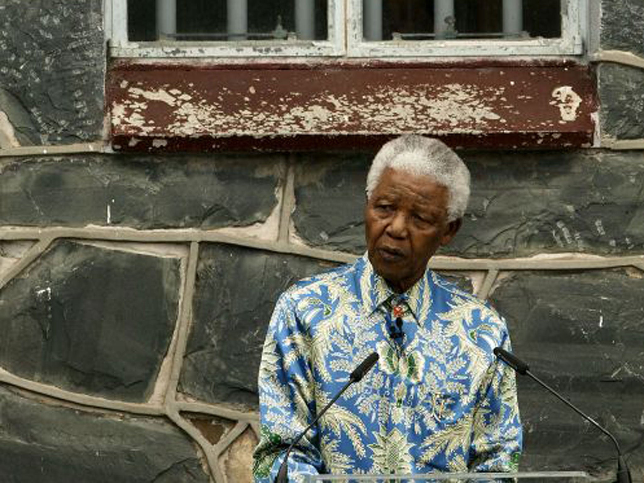 Nelson Mandela outside his former prison cell attends a press conference for "46664 - Give One Minute of Your Life to AIDS" on November 28, 2003