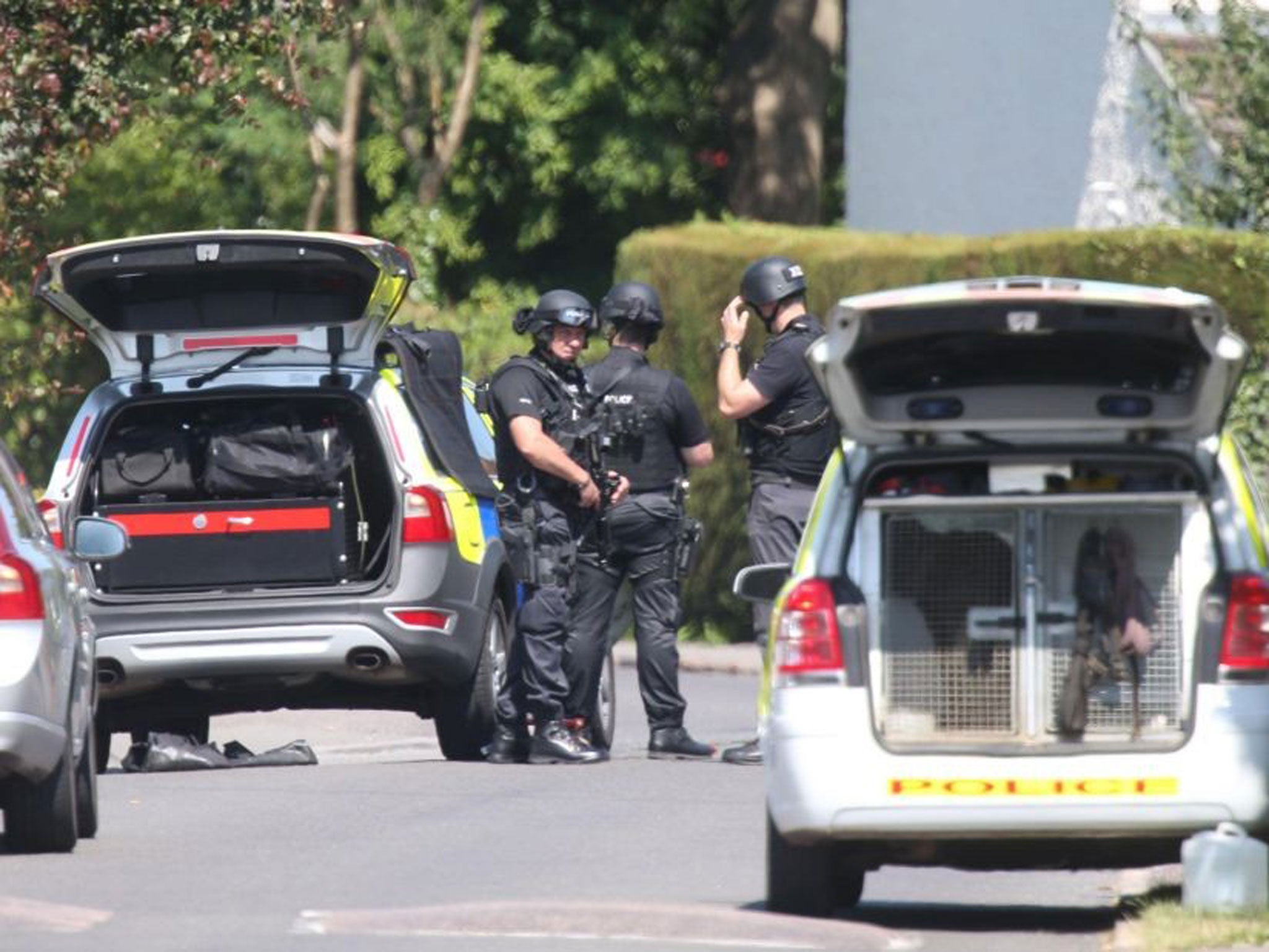 Police wait near a property where twin girls were held by their father