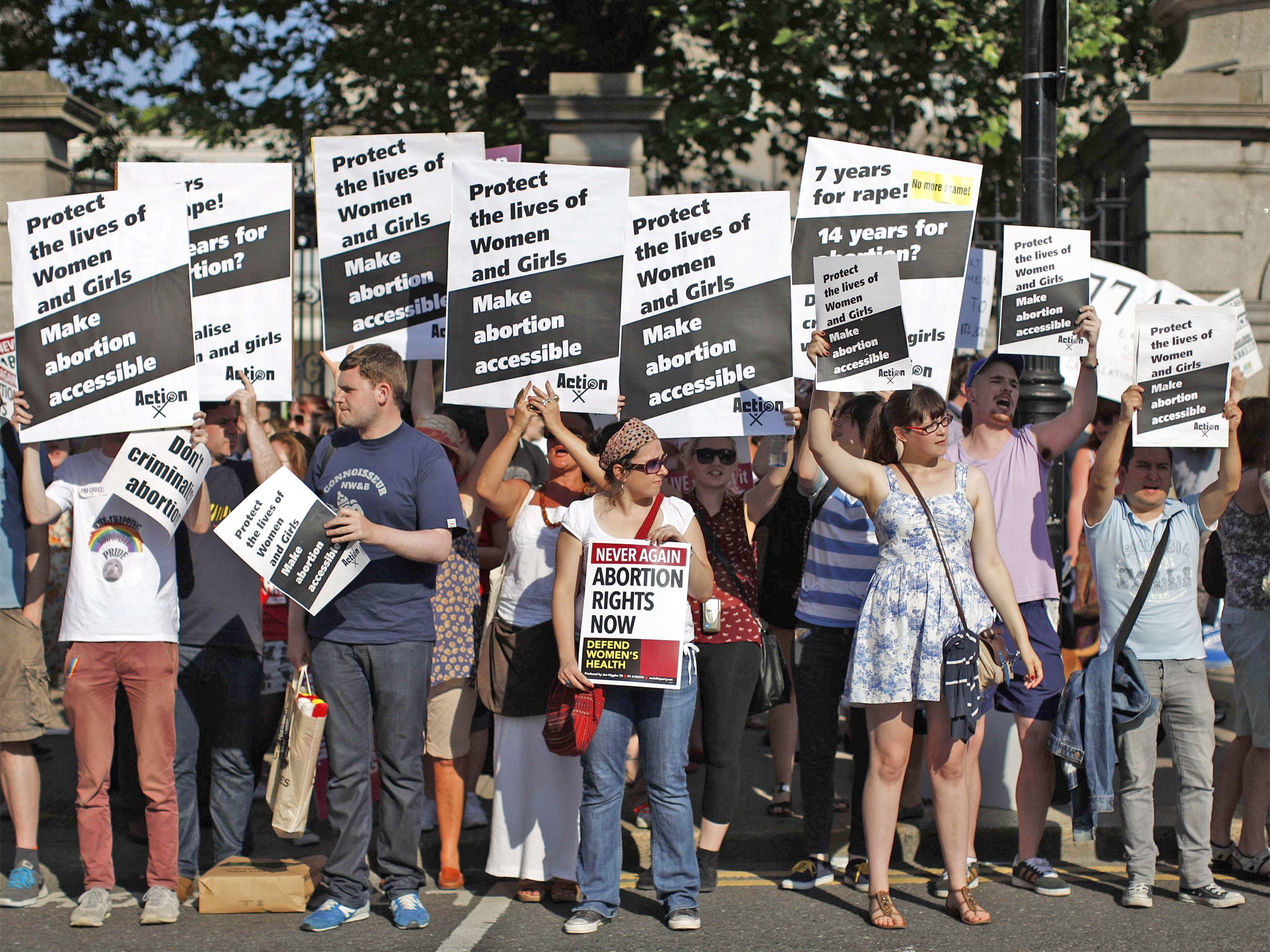 Pro-choice supporters hold placards in front of the Irish Parliament