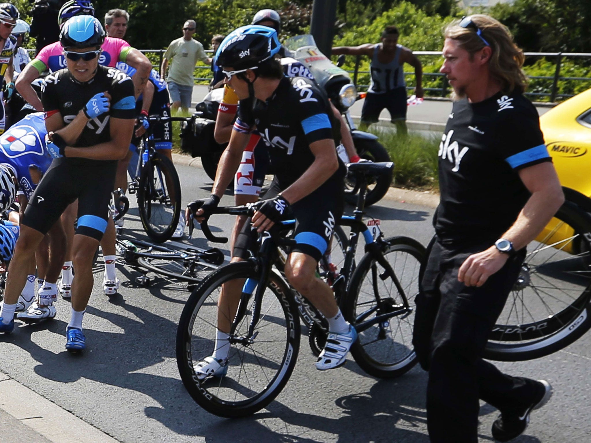 Sky’s Boasson Hagen (left) feels his injured shoulder after crashing on stage 12