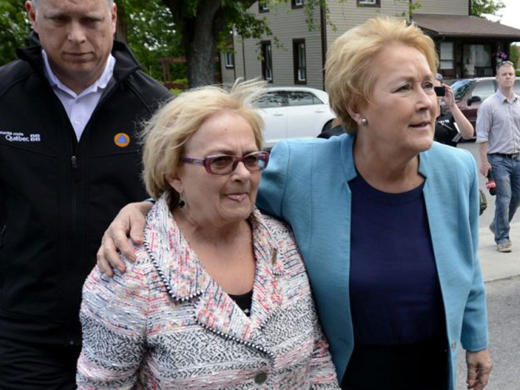 Quebec Premier Pauline Marois, right, puts her arm around Lac-Megantic, Quebec Mayor Colette Roy-Laroche as she arrives