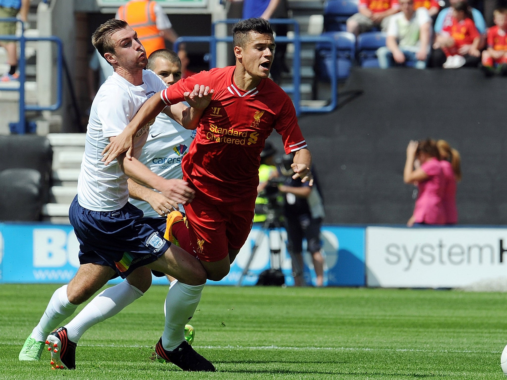 Philippe Coutinho of Liverpool is brought down by Paul Huntington of Preston North End during the Preston North End and Liverpool pre season friendly at Deepdale