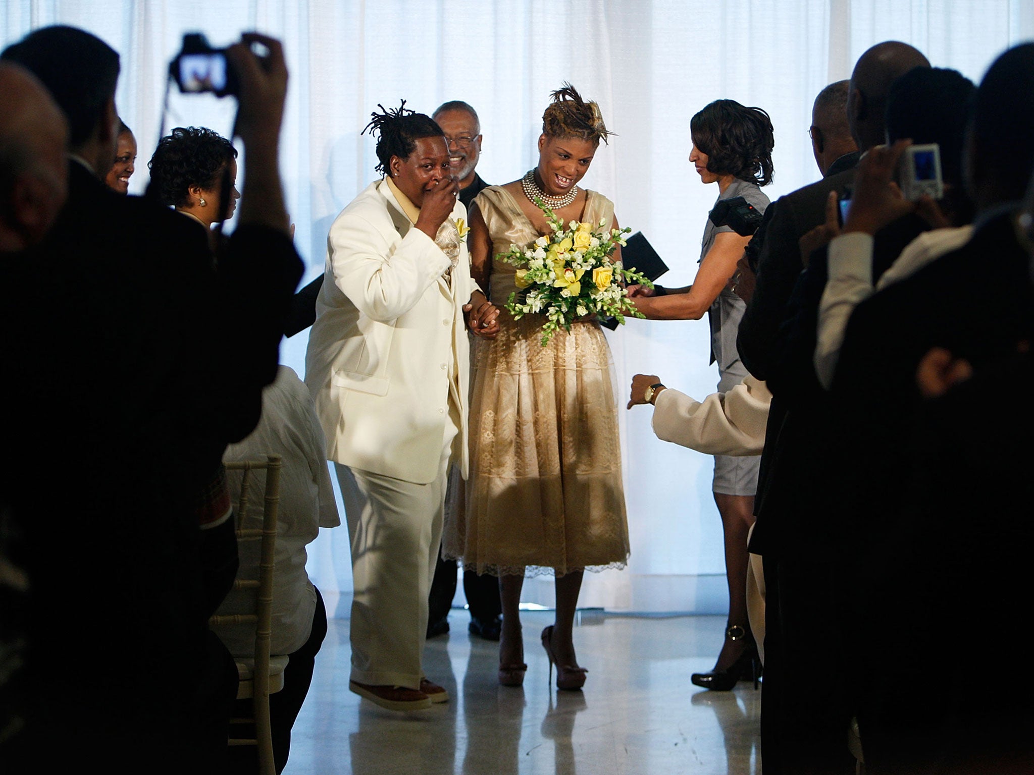 Angelisa Young (R) and Sinjoyla Townsend (L) rejoice as Rev. David North (C) looks on during their wedding on the first day same-sex couples are legal to wed under a new law March 9, 2010 in Washington, DC.