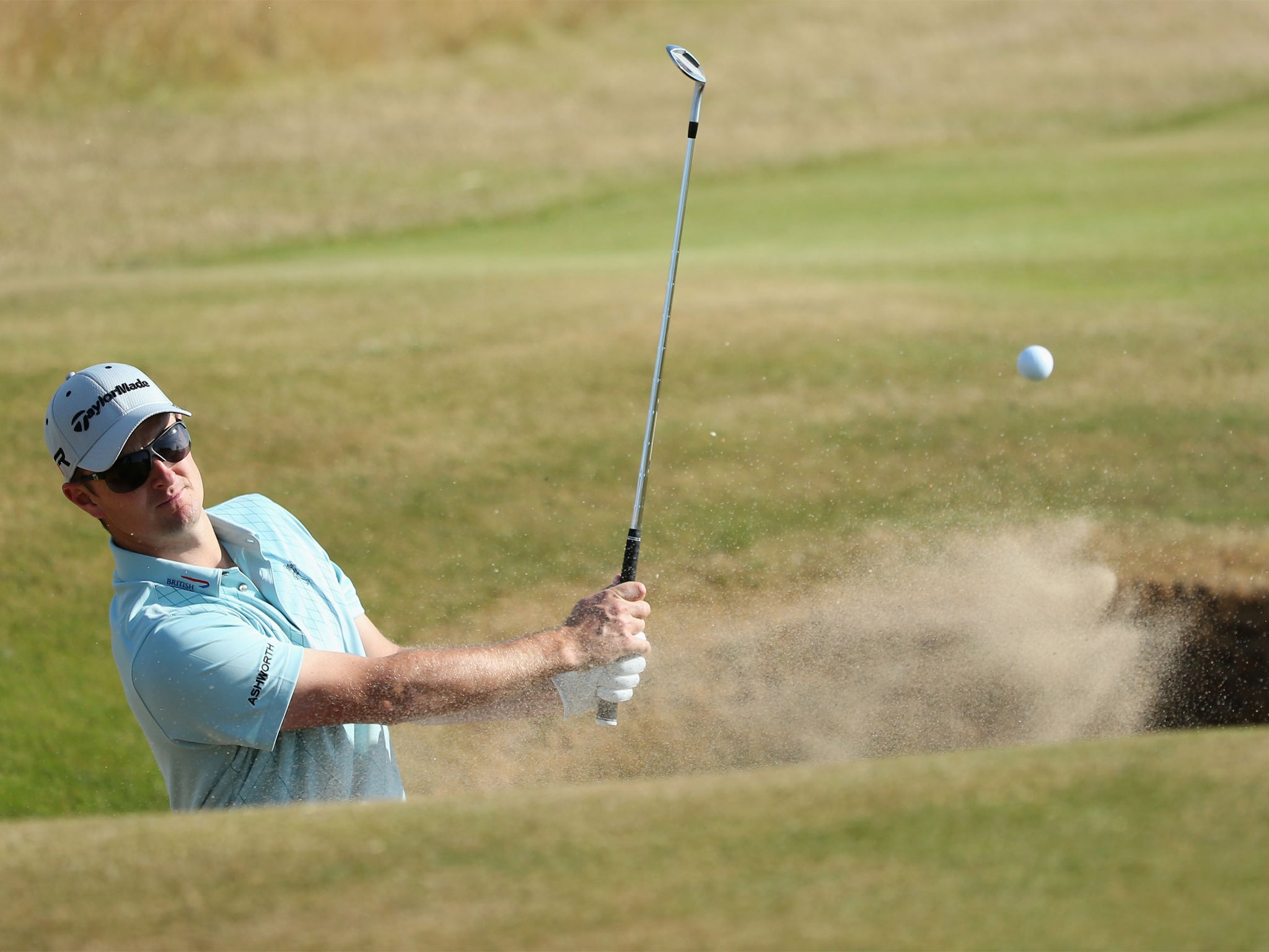 Justin Rose plays out of a bunker during practice