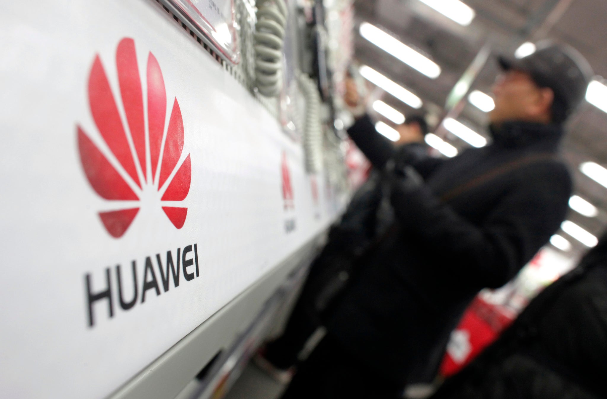 2013A man looks at a Huawei mobile phone as he shops at an electronic market in Shanghai January 22, 2013. REUTERS/Carlos Barria