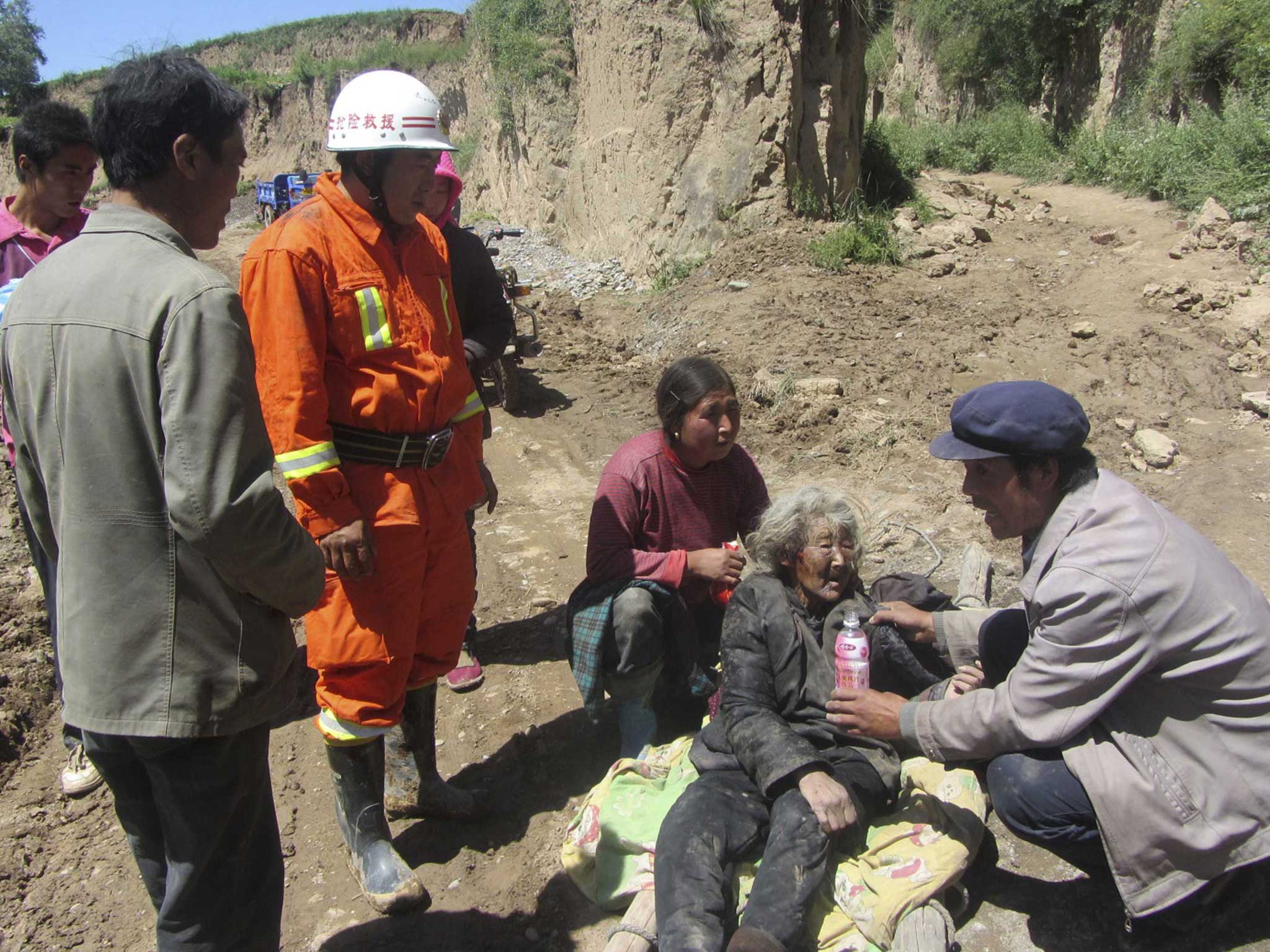 A man feeds water to an injured woman following the earthquake