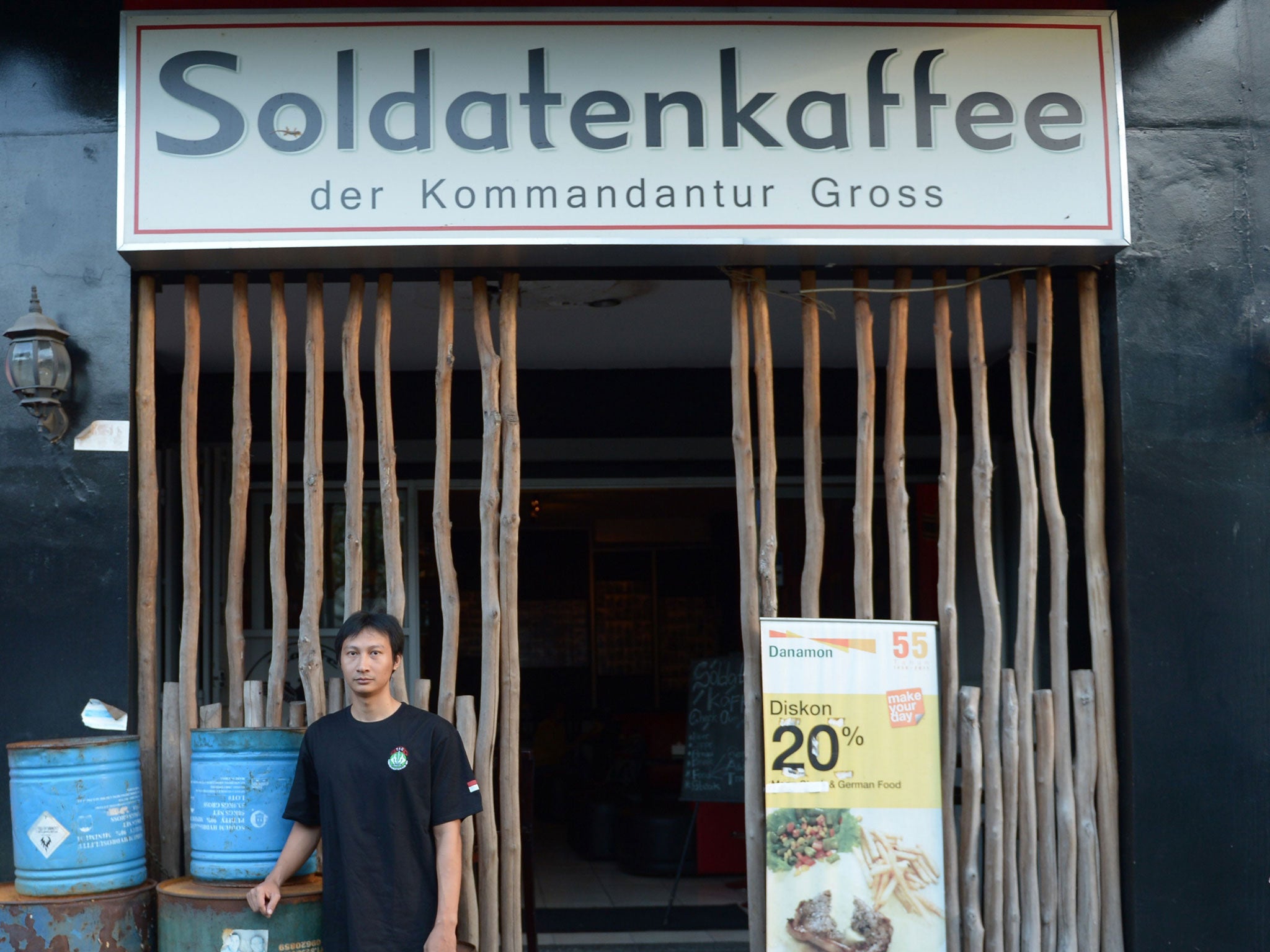 Henry Mulyana standing outside the Soldatenkaffe 'The Soldiers' Cafe' in Bandung