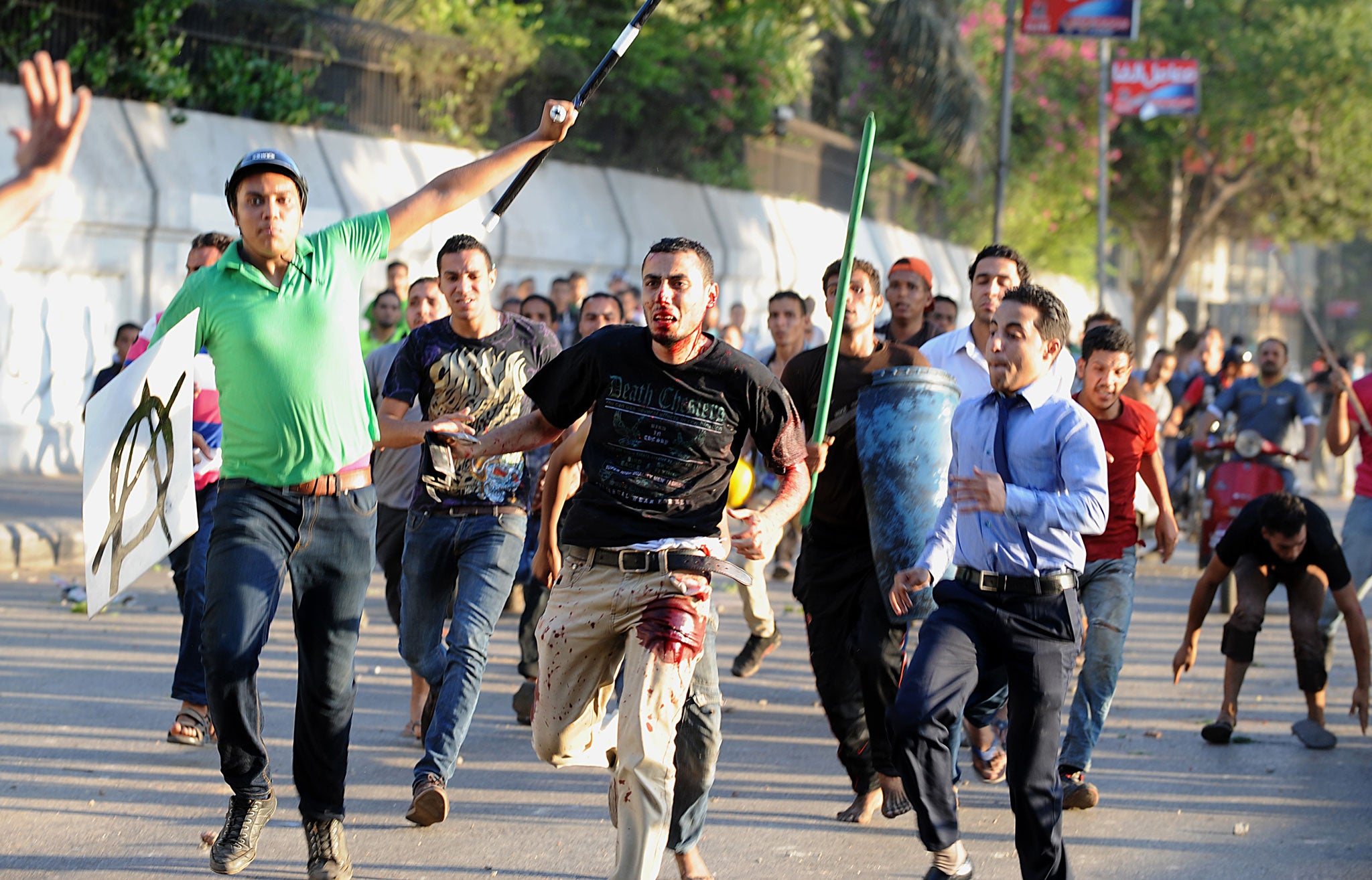 A supporter of deposed Egyptian President Mohamed Morsi is seen beaten by pro-government and army supporters during clashes that erupted at Tahrir Square and around the US Embassy in Cairo