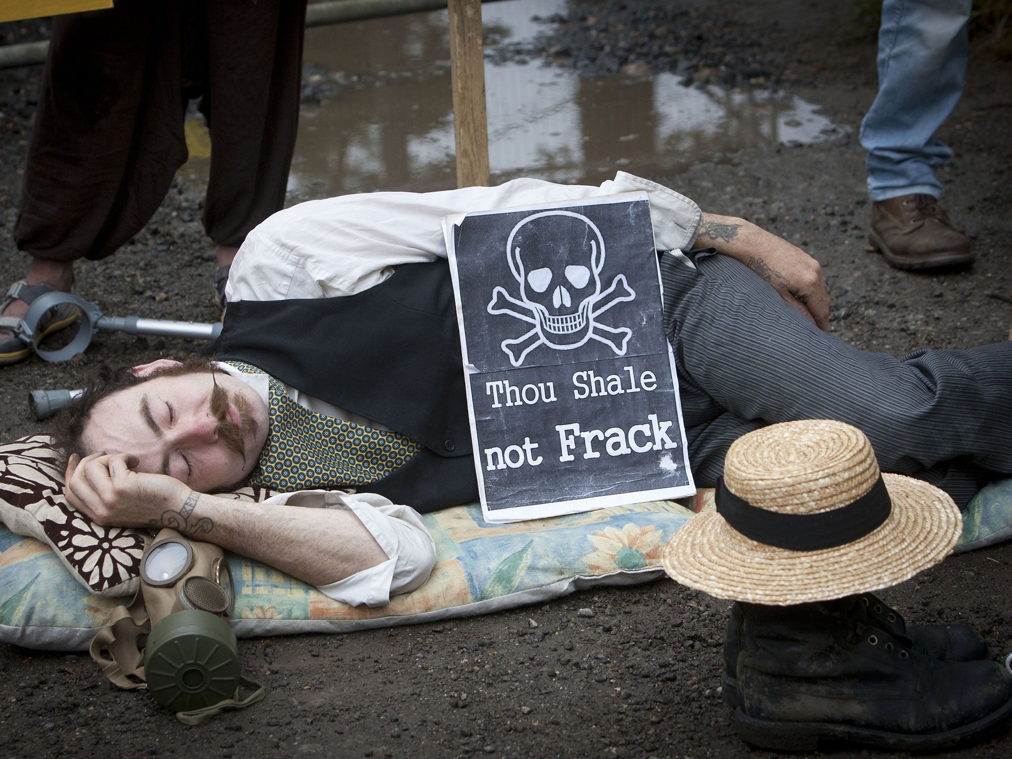 A protestor lies down in front of the entrance gate