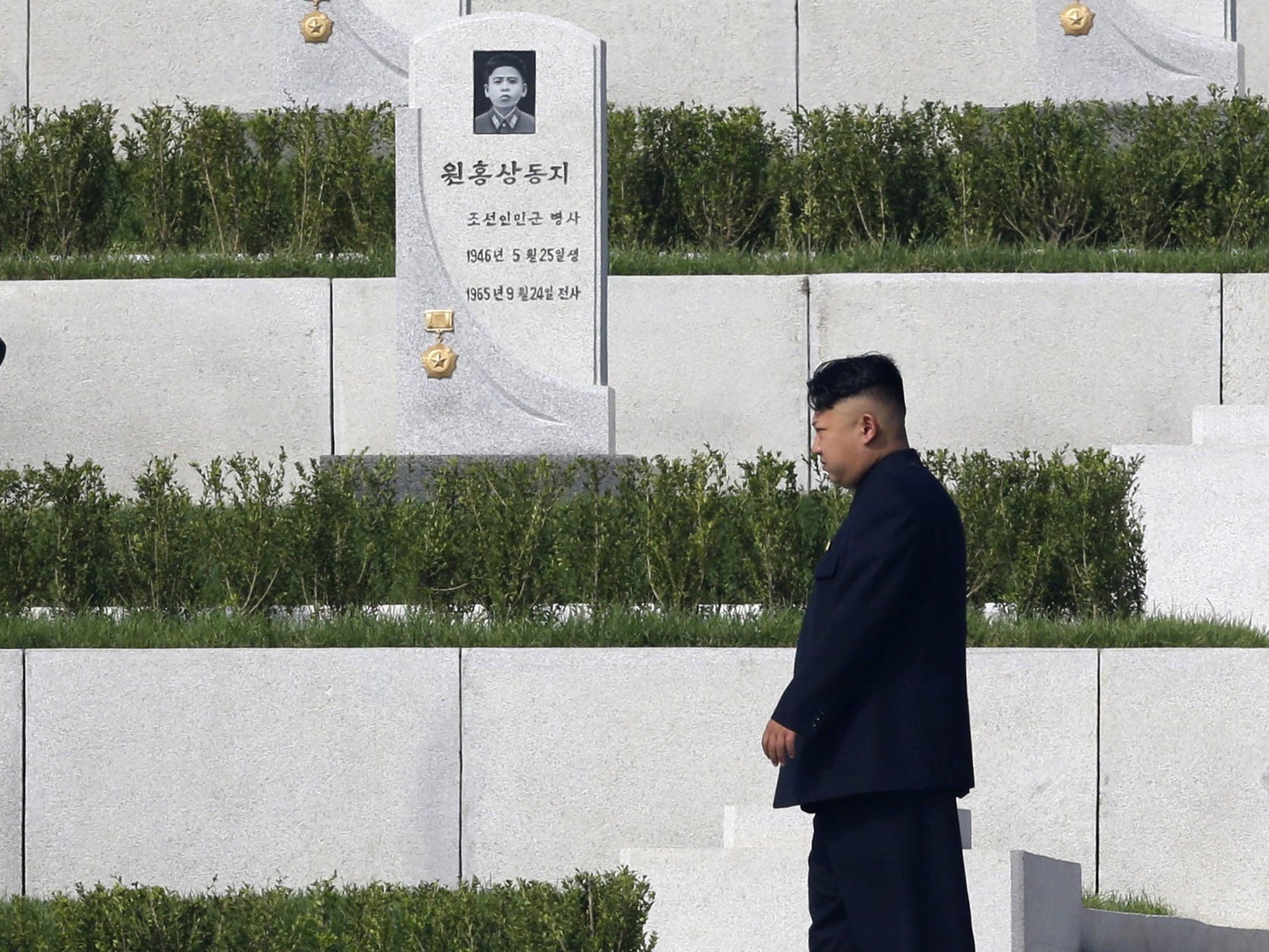 Kim Jong-un walks past tombstones at the opening of the Cemetery of Fallen Fighters in Pyongyang