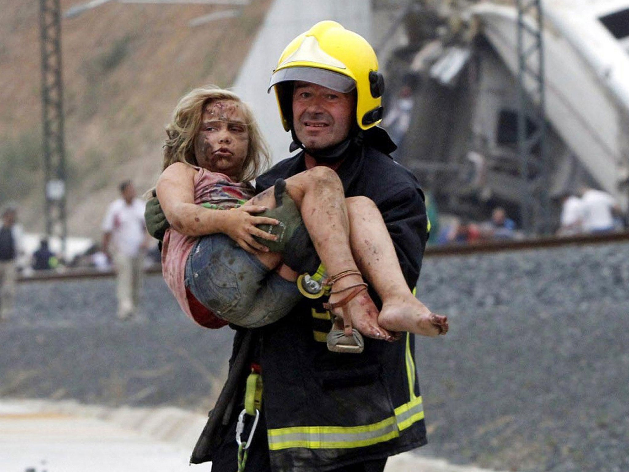 An injured girl is carried from the wreckage of the crash near Santiago de Compostela