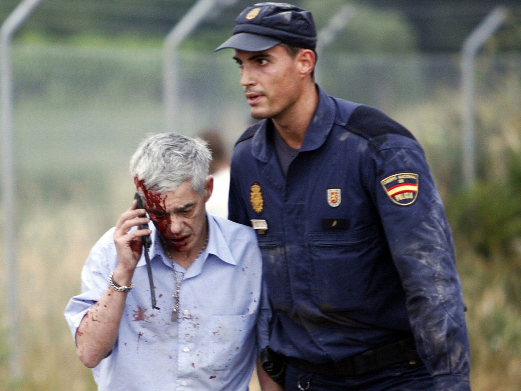 Train driver Francisco Jose Garzon, is helped by a policeman after a train crashed near Santiago de Compostela