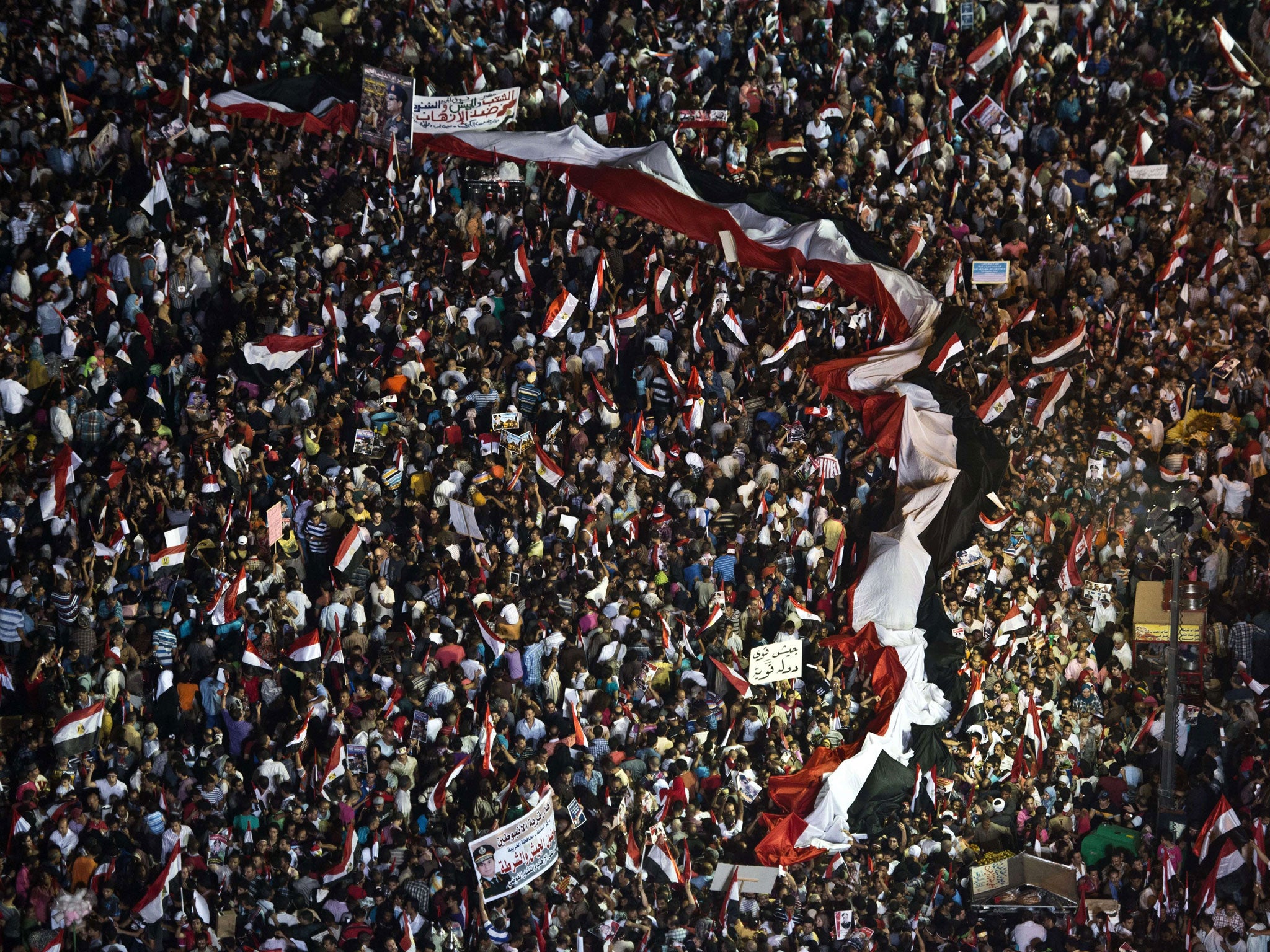 Supporters of Egyptian Armed Forces General Ahmed Fattah al-Sisi wave national flags as they rally at Tahrir Square