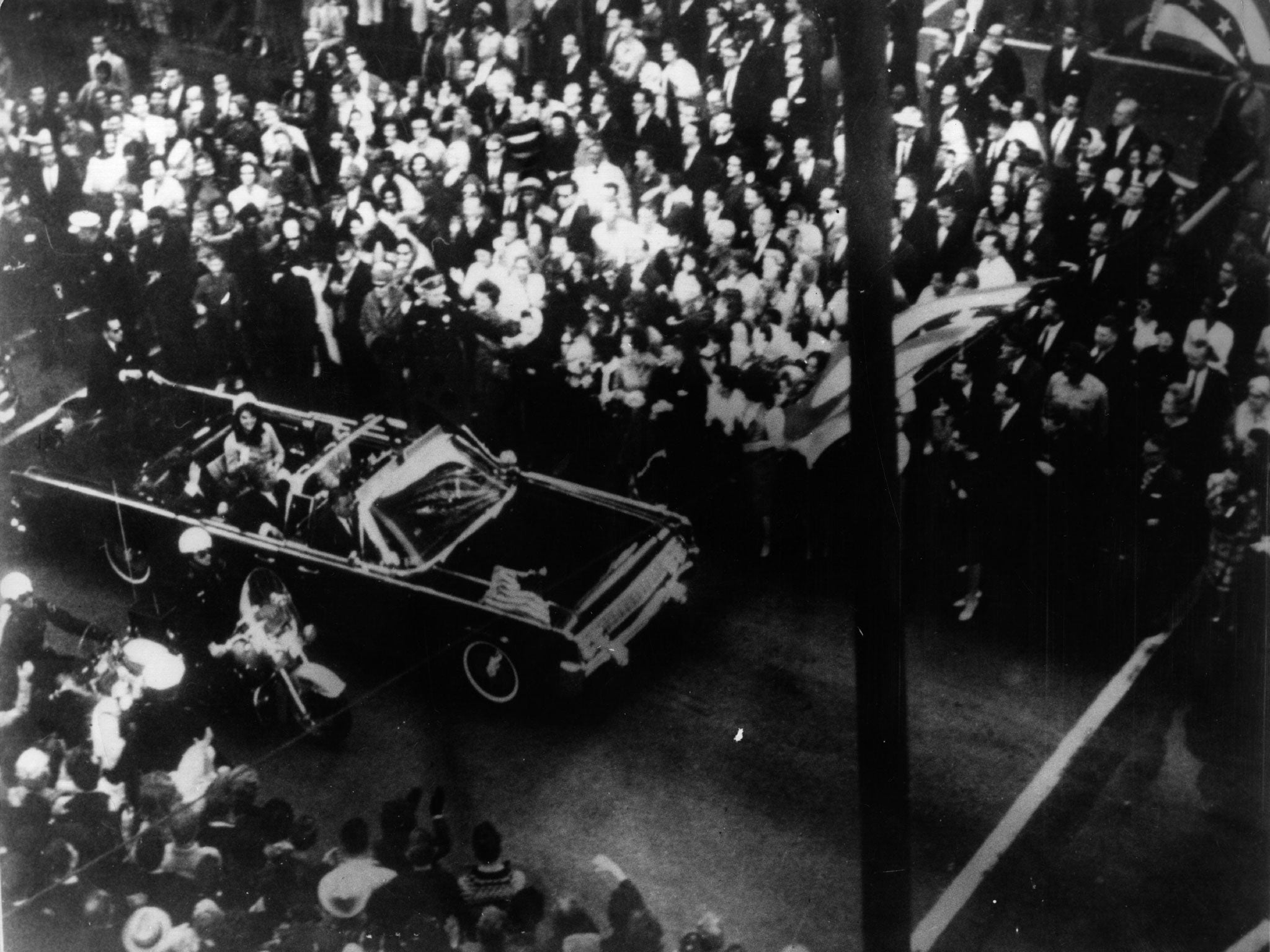 John F Kennedy and his wife Jackie Kennedy travelling in the presidential motorcade at Dallas, before his assassination