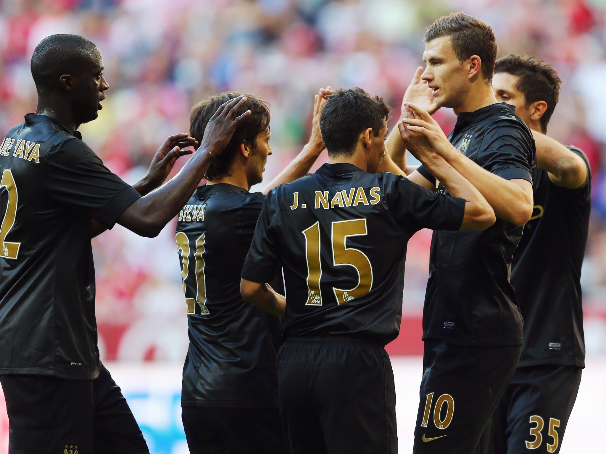 Edin Dzeko is congratulated by team-mates after scoring against AC Milan