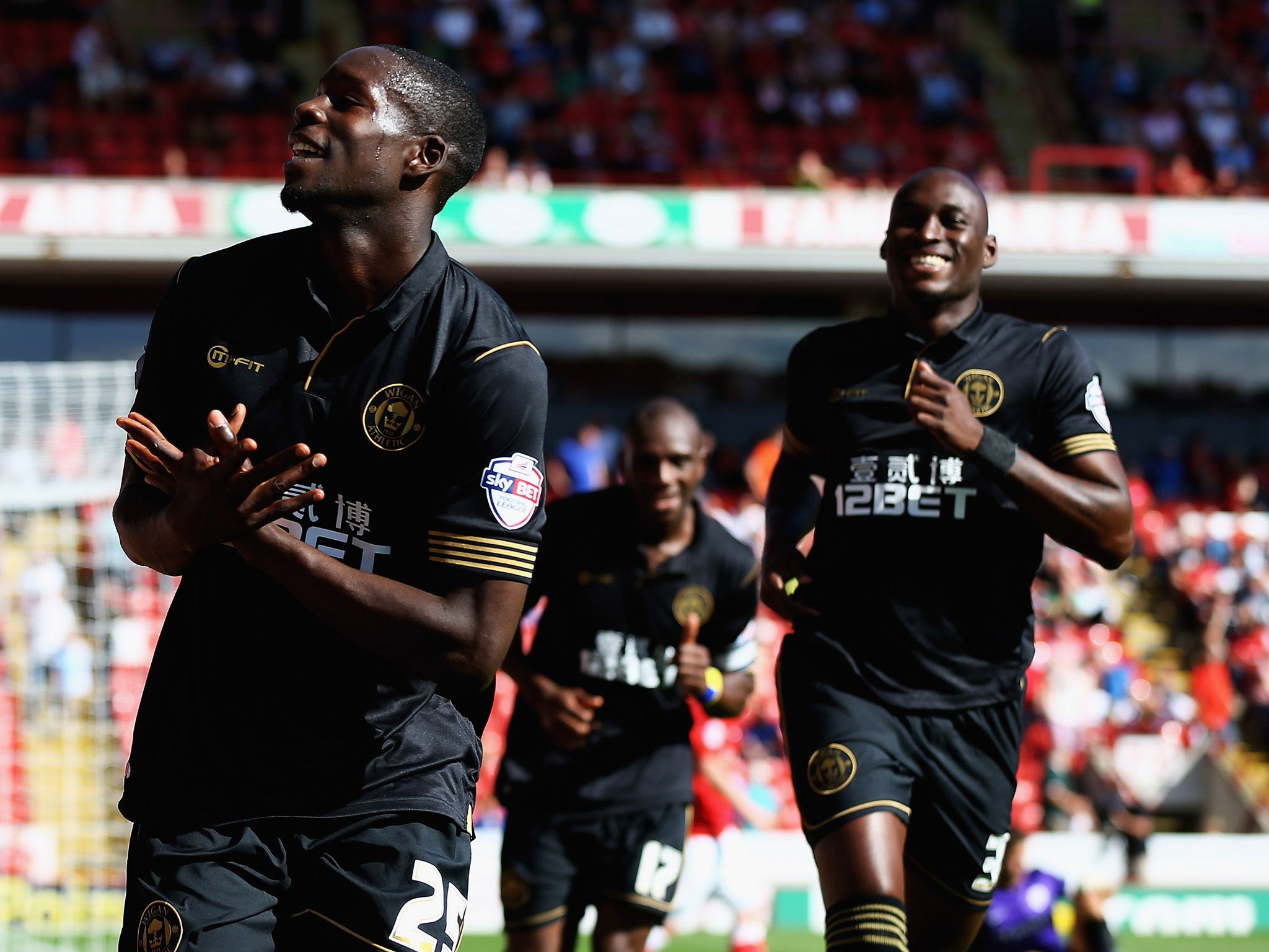 Wigan’s Leon Barnett, left, celebrates after scoring