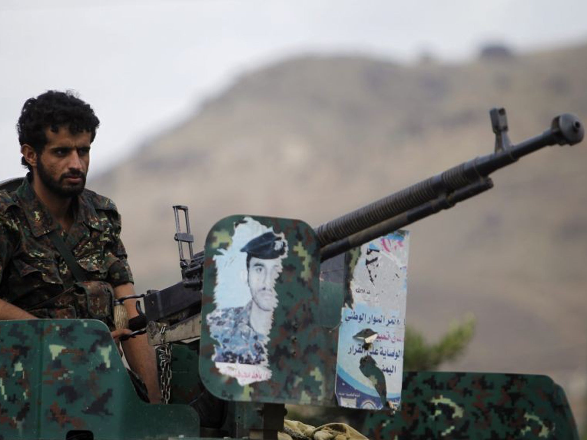 A police trooper mans a machine gun mounted on an armoured personnel carrier positioned near the British embassy in Sanaa