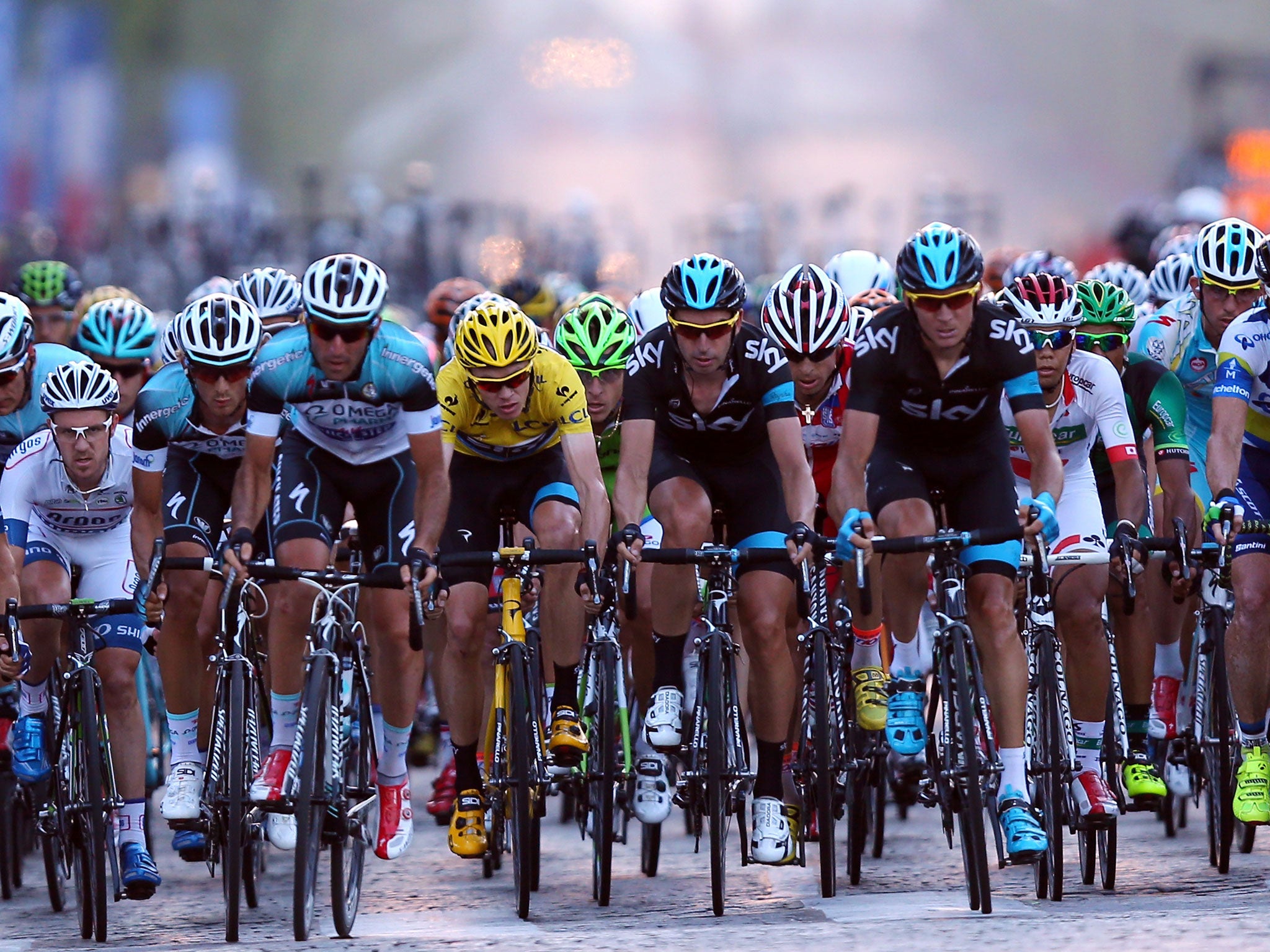 Chris Froome, in yellow, rides in the bunch during the twenty first and final stage of the 2013 Tour de France