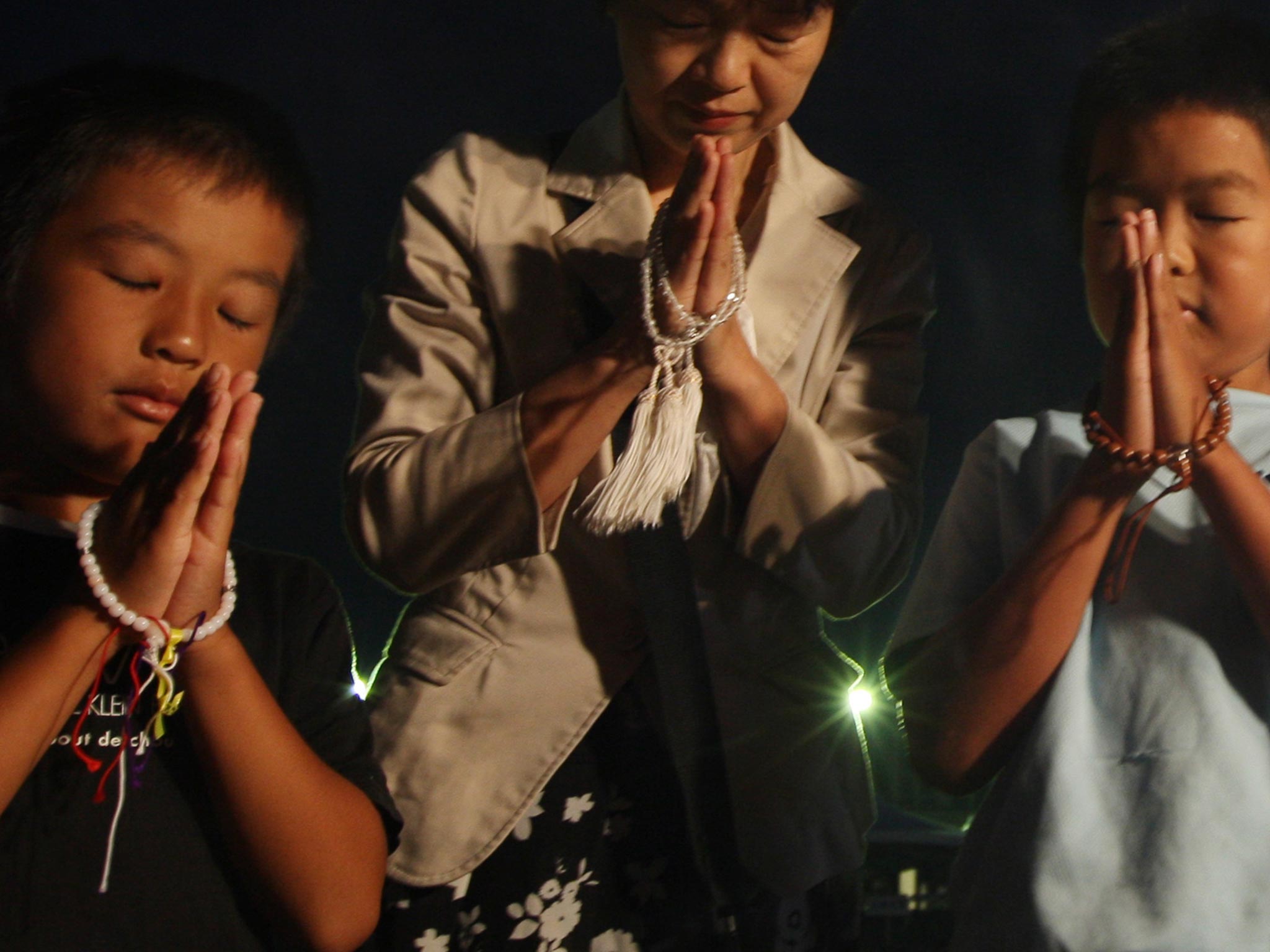 A mother and her children pray for atomic bomb victims