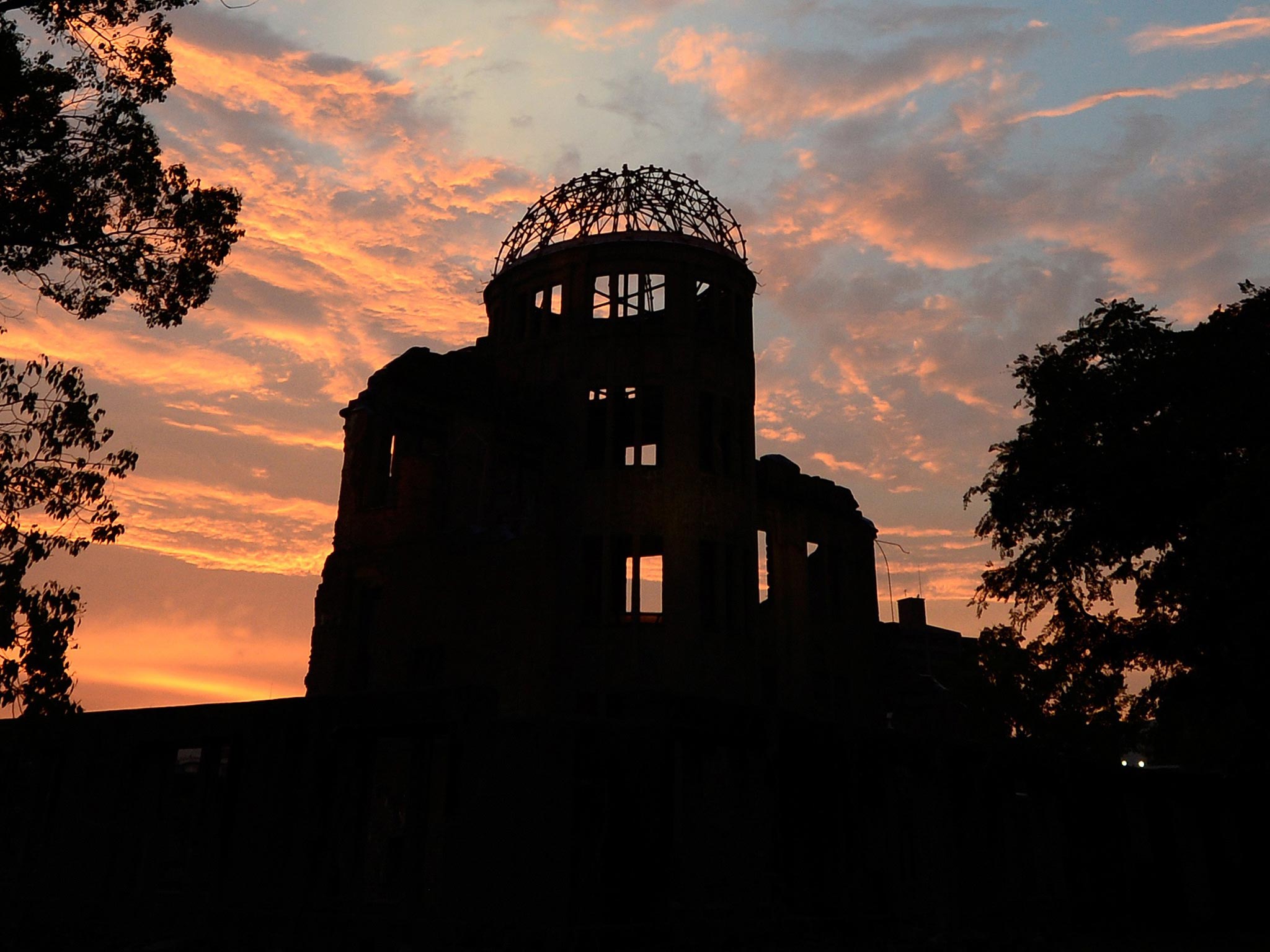 The Atomic Bomb Dome is seen in silhouette during sunset over the Peace Memoral Park in Hiroshima