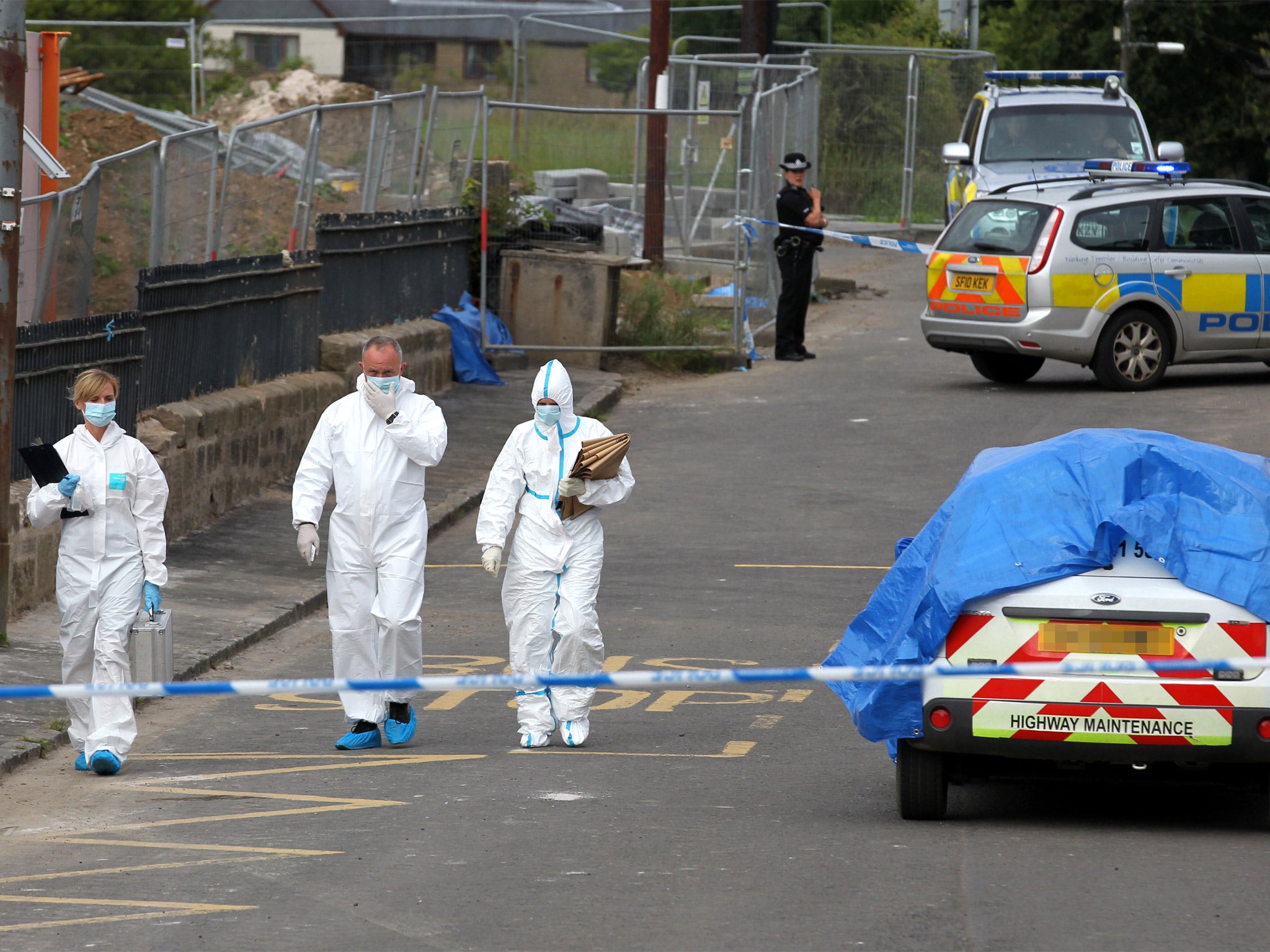 Police forensics examine the scene on Auldhouse main street