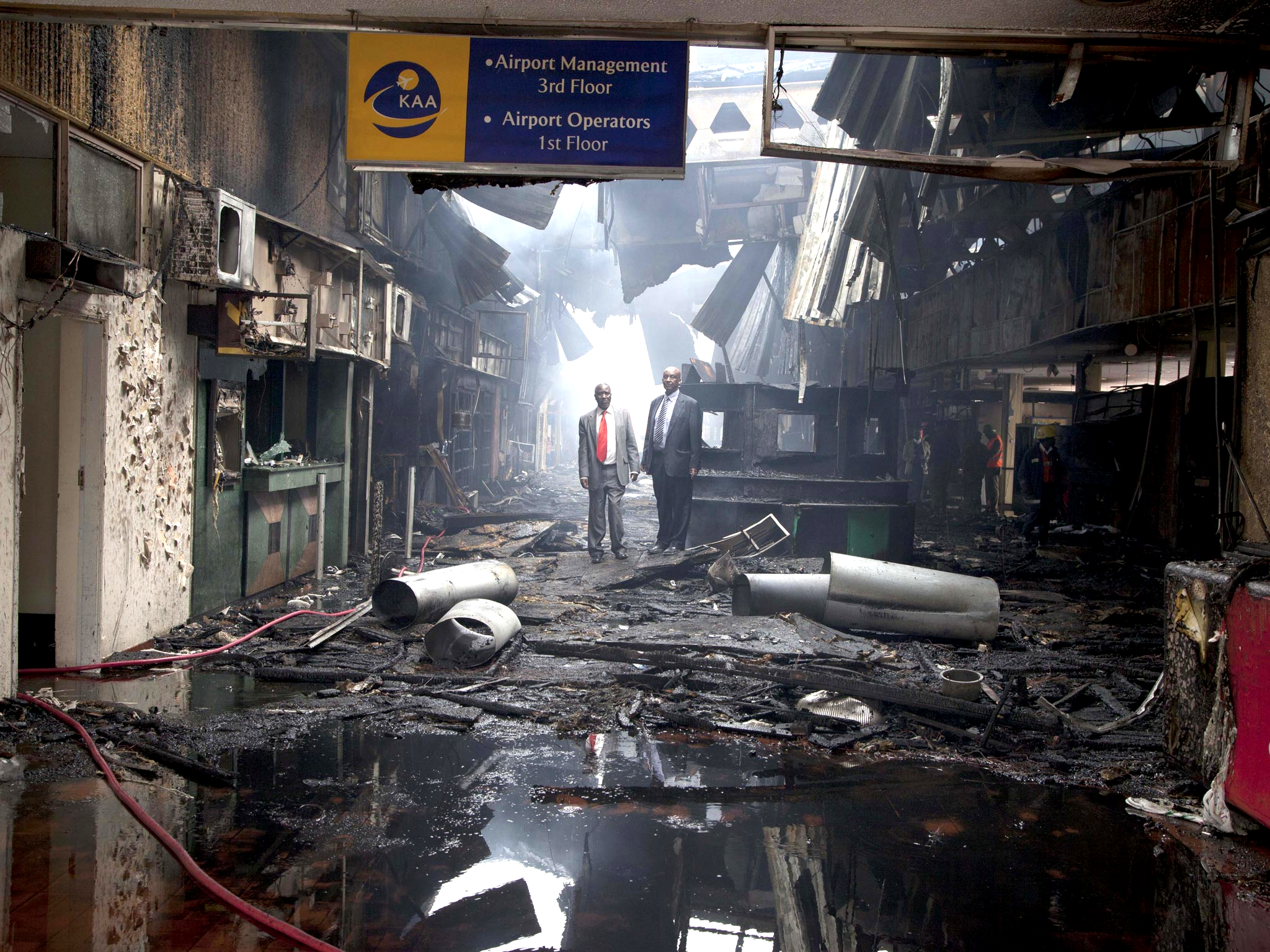 Kenyan airport officials view the damage after a fire engulfed the international arrivals area of Jomo Kenyatta International Airport, in Nairobi, Kenya