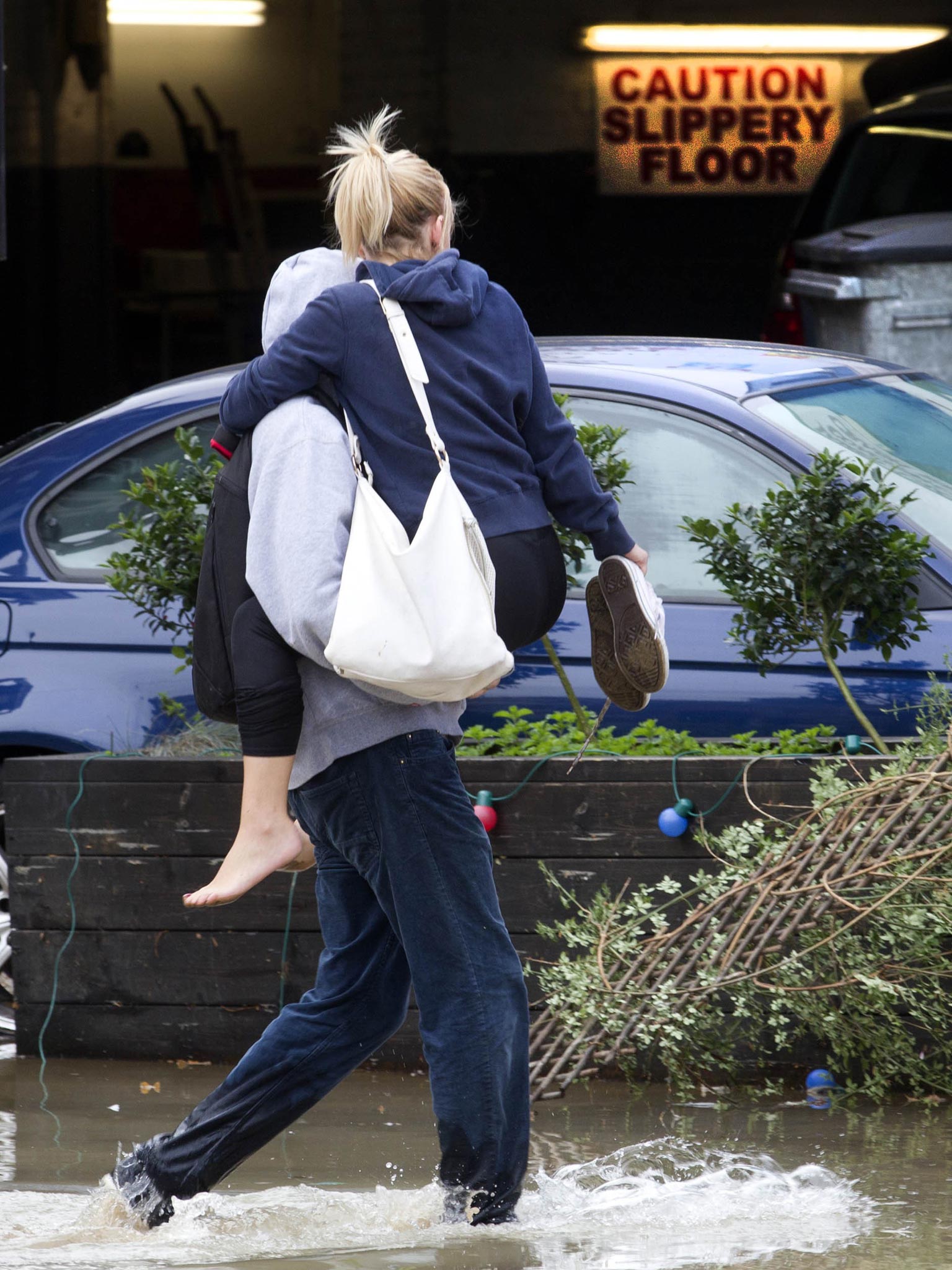 A man helps a lady through the water