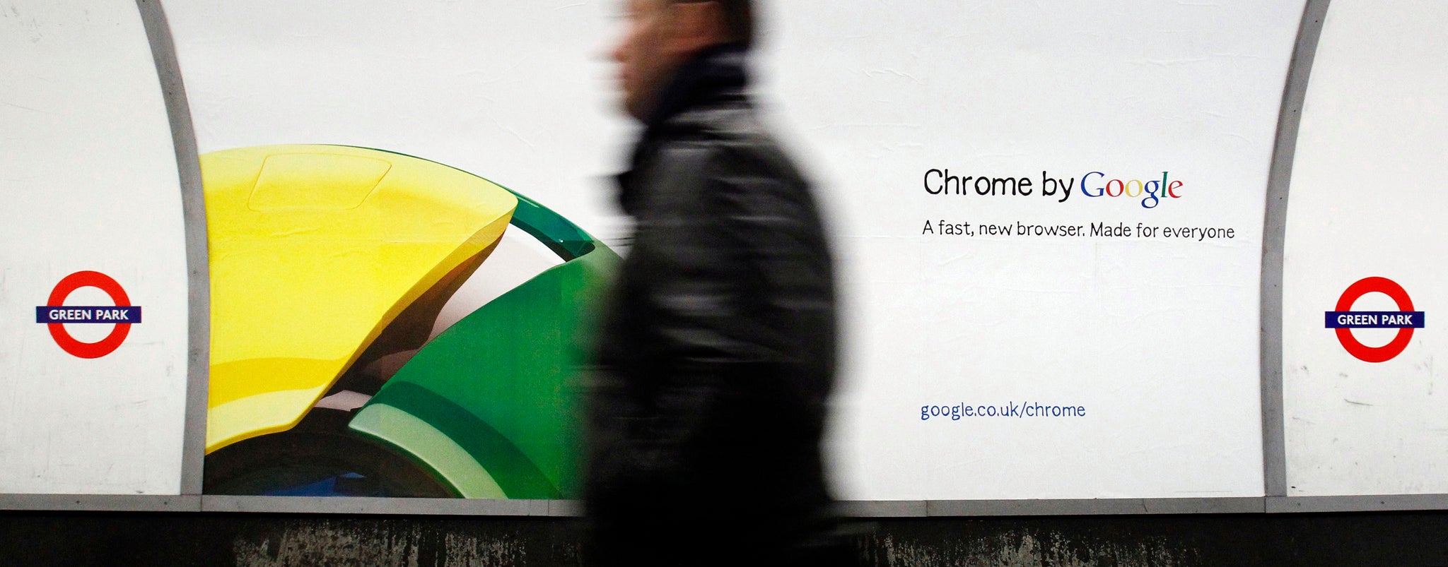 A man walks past a poster for Google's Chrome browser in an underground station in central London January 25, 2010. REUTERS/Luke MacGregor