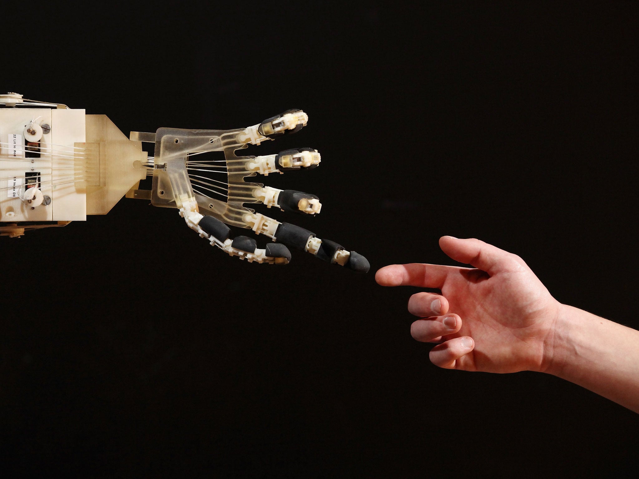 Robotics student Gildo Andreoni interacts with a Dexmart robotic hand built at the University of Bologna in the Robotville exhibition at the Science Museum on November 29, 2011 in London, England.