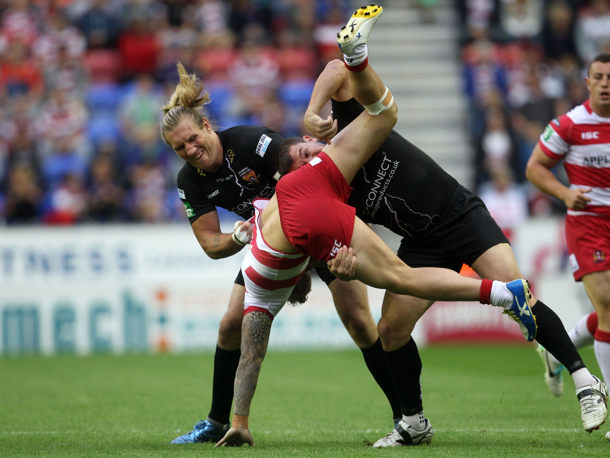 Josh Charnley (centre) cannot break the Huddersfield cover