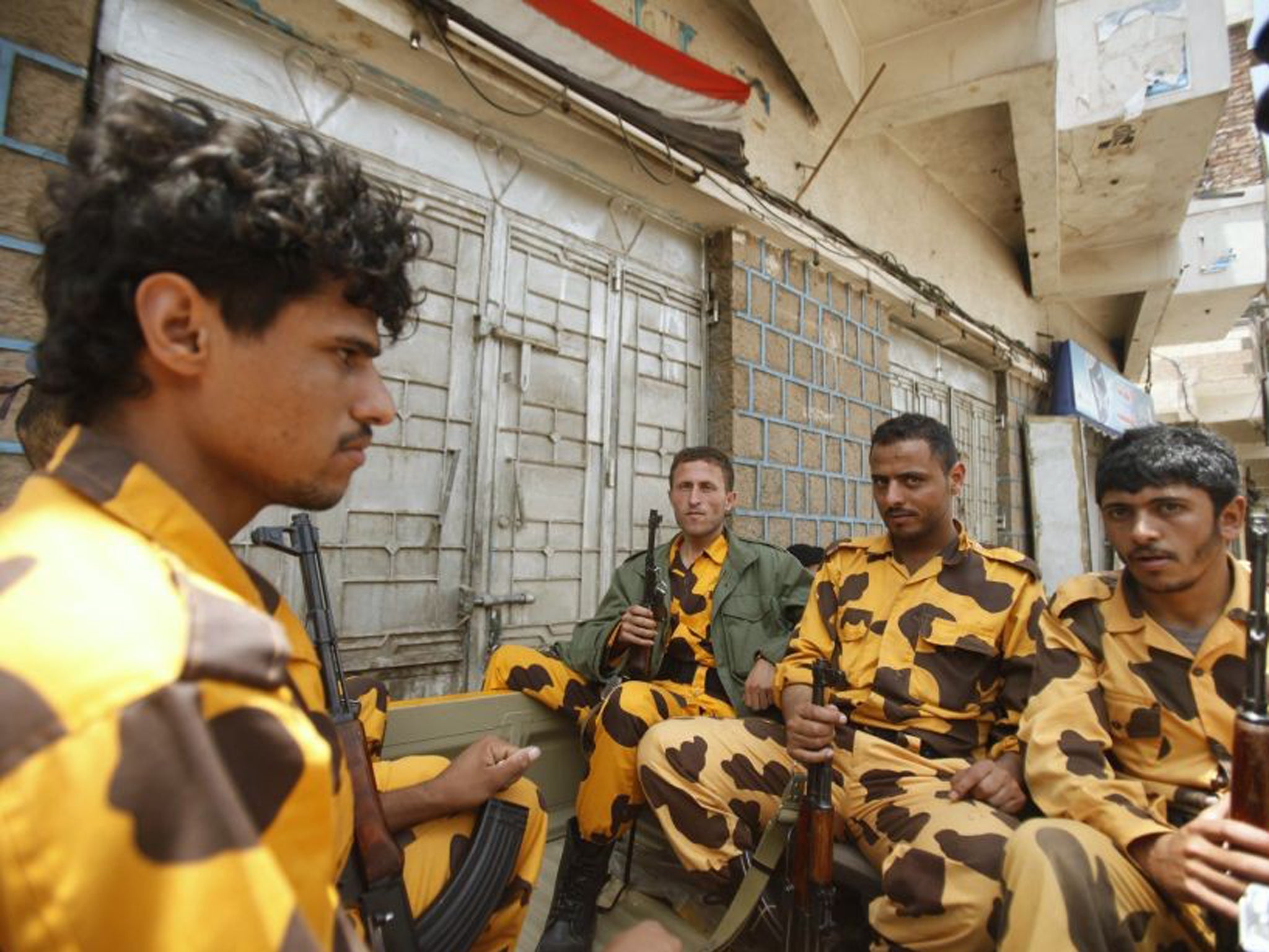 Police troopers sit on a patrol vehicle positioned at a checkpoint on a street in the Yemeni capital Sanaa, where the US embassy remains closed