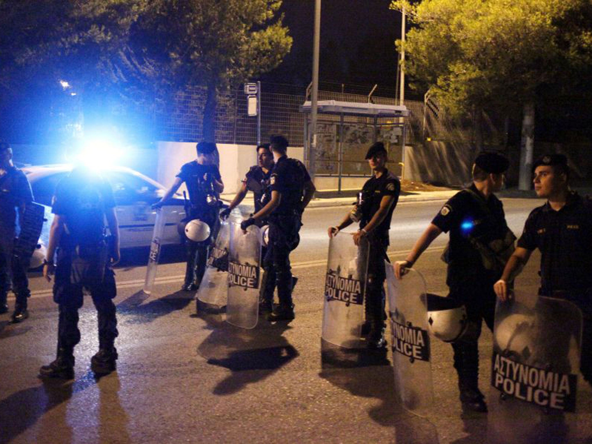 Police blocks the access to the Amygdaleza detention camp outside Athens, where some 1,200 mainly Asian migrants are kept under police guard