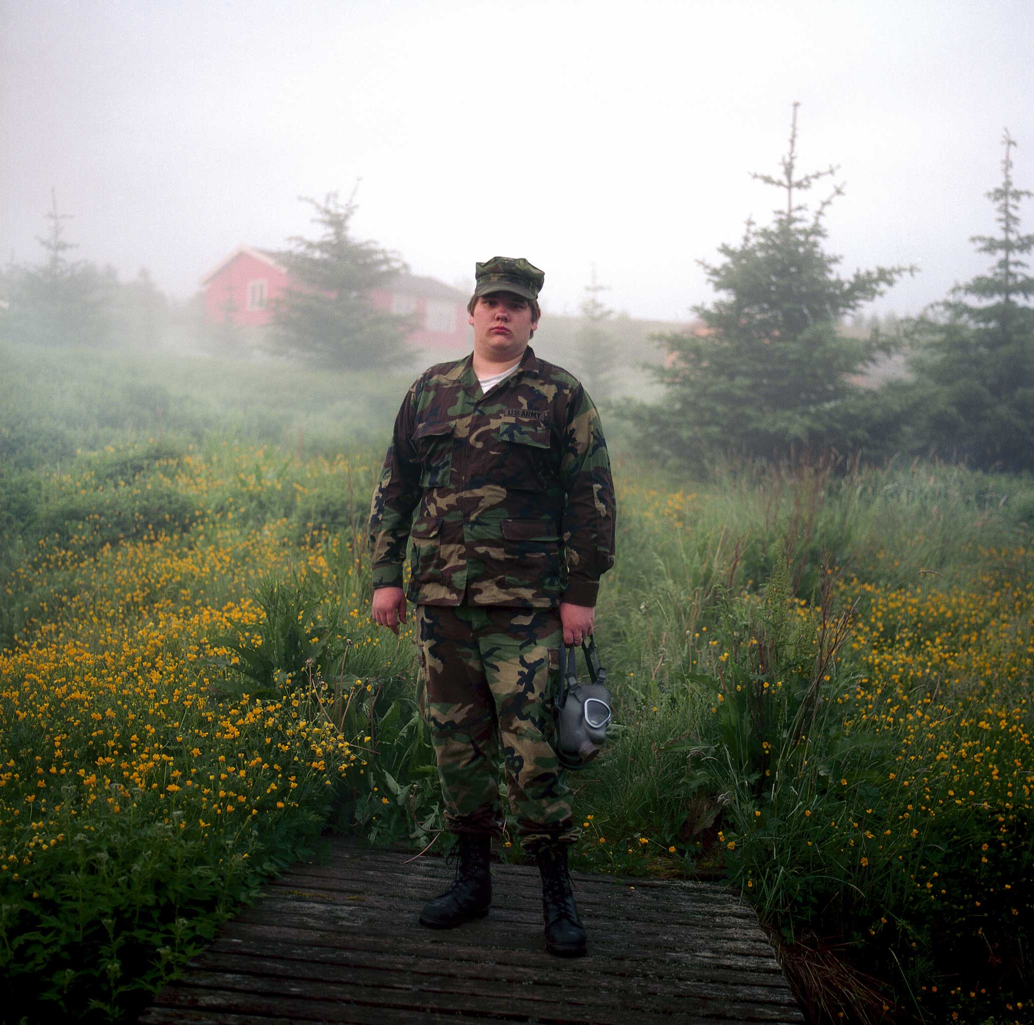 Mati on a wooden bridge in the midnight mist; the bridge was built by the residents a couple of years ago to allow them to cross over a stream flowing from a hot spring that supplies all their water. Mati admires anything army-related, and passionately collects military accessories