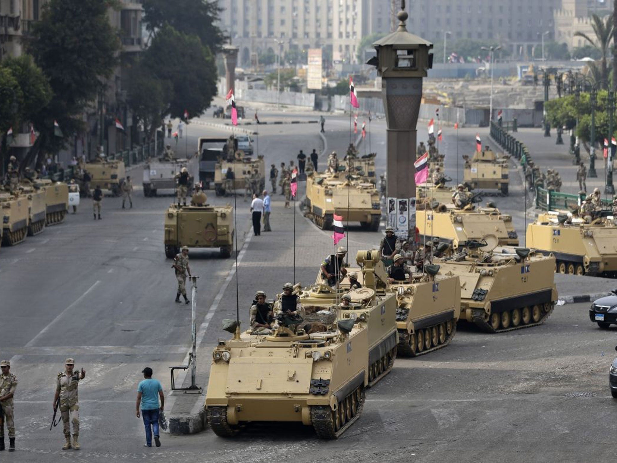 Egyptian army soldiers take their positions on top and next to their armored vehicles while guarding an entrance to Tahrir square, in Cairo, Egypt, Friday, Aug. 16, 2013