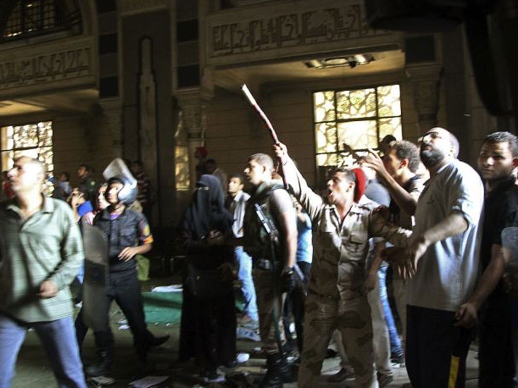 A member of the army points to the second floor of the mosque with a stick during clashes with supporters of deposed Egyptian President Mohamed Morsi inside a room of the al-Fath mosque in Cairo 17, August.