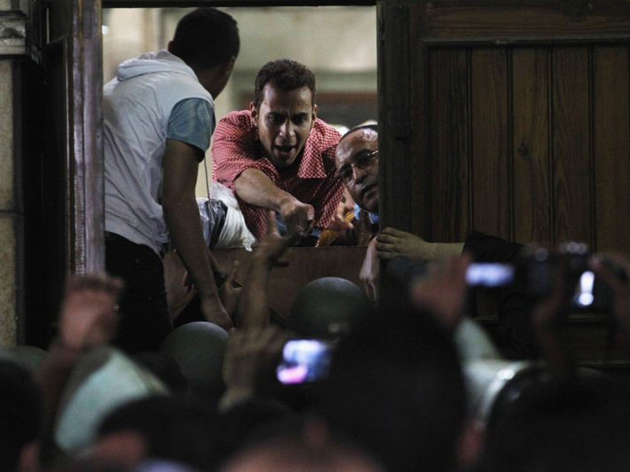 Supporters of deposed Egyptian President Mohamed Mursi talk with media and police from behind their barricade inside the al-Fath mosque in Cairo on 17 August