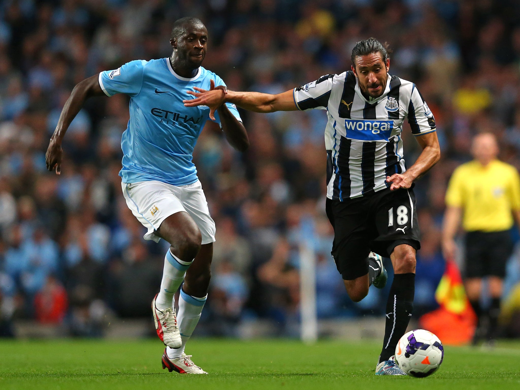 Jonas Gutierrez (r) competes with Yaya Toure (l)