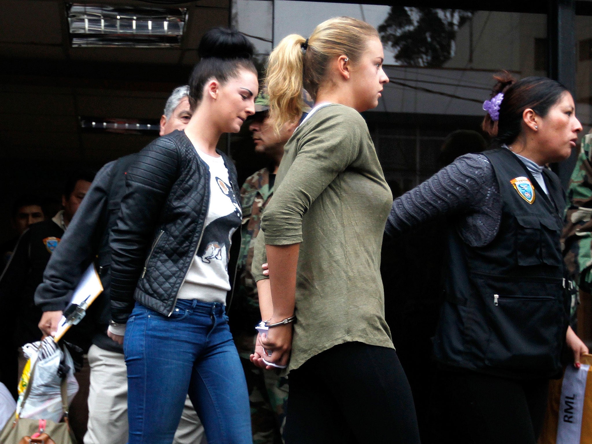 Police escort Michaella McCollum Connolly, left, and Melissa Reid in handcuffs on their way to court