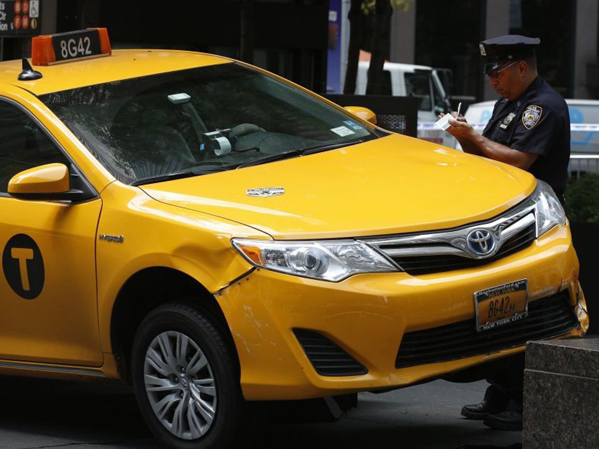 New York City Police officers investigate the taxi cab that jumped a curb and hit several pedestrians in New York's Rockefeller Center