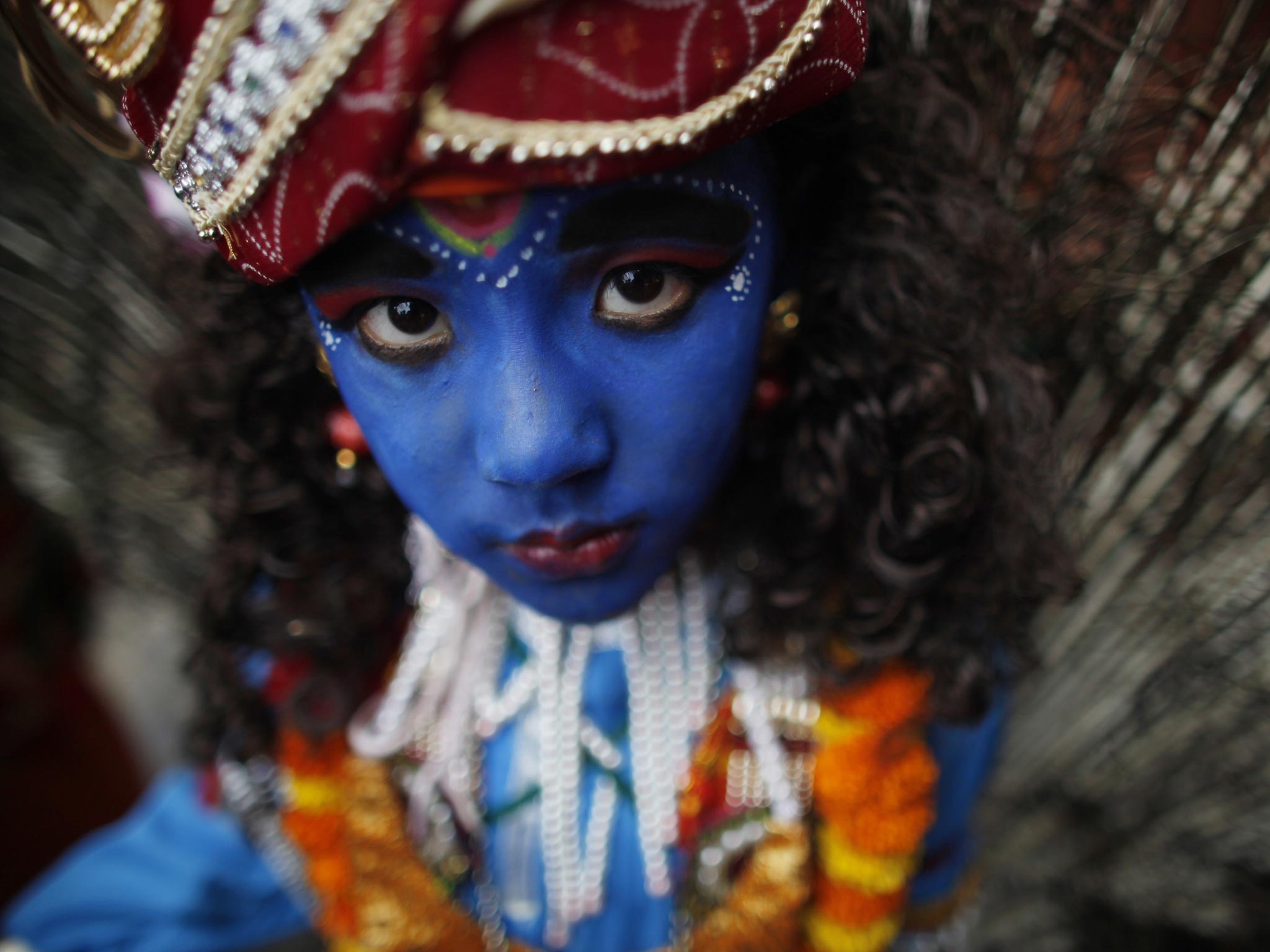 A Nepalese Hindu boy dressed as Hindu deity Lord Krishna looks on during "Gai Jatra," or Cow Festival, in Katmandu, Nepal